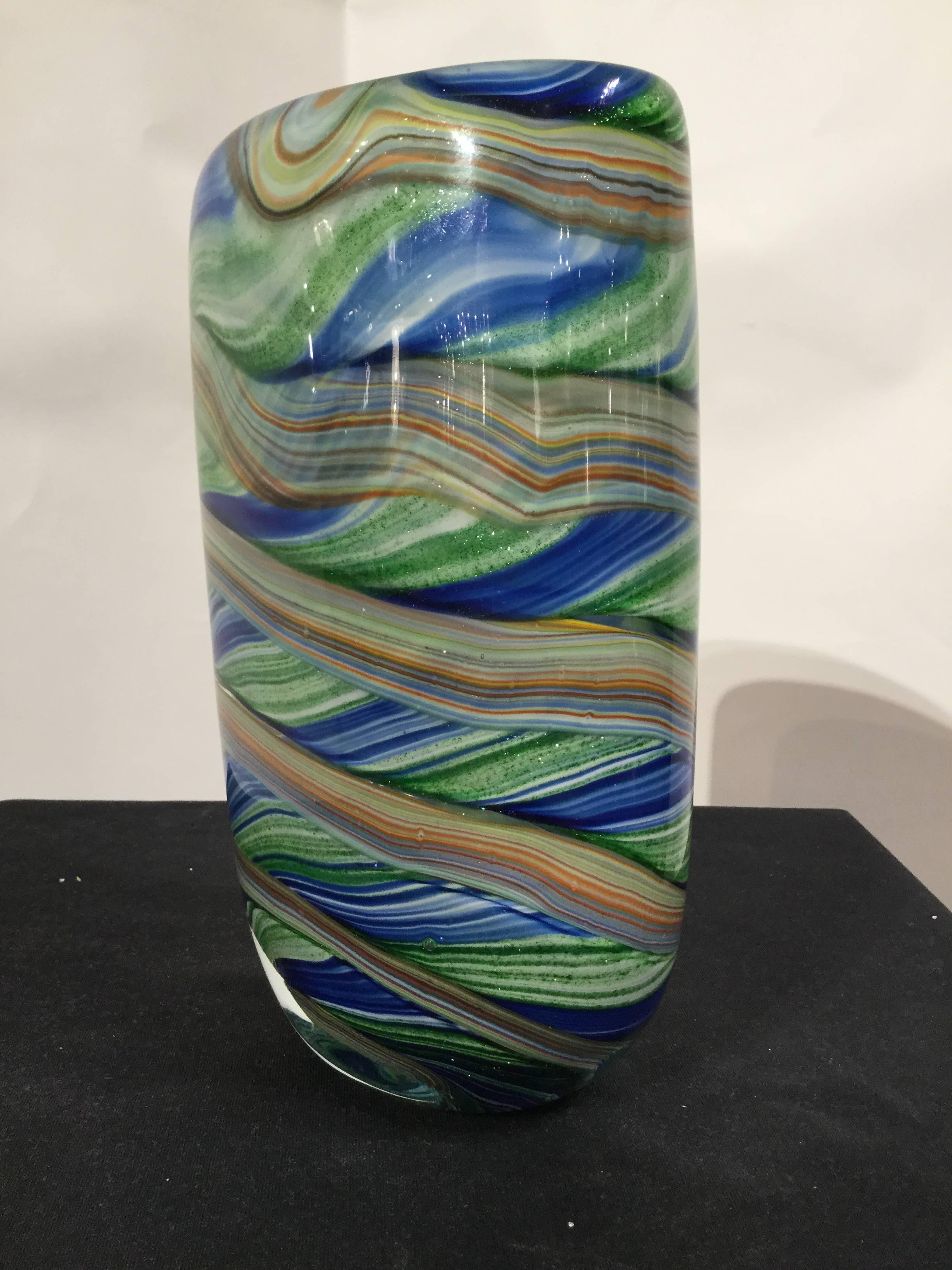 A multicolor Venetian glass vase depicted in post-impressionist style with yellow, brown, green, blue and orange stripes.
 