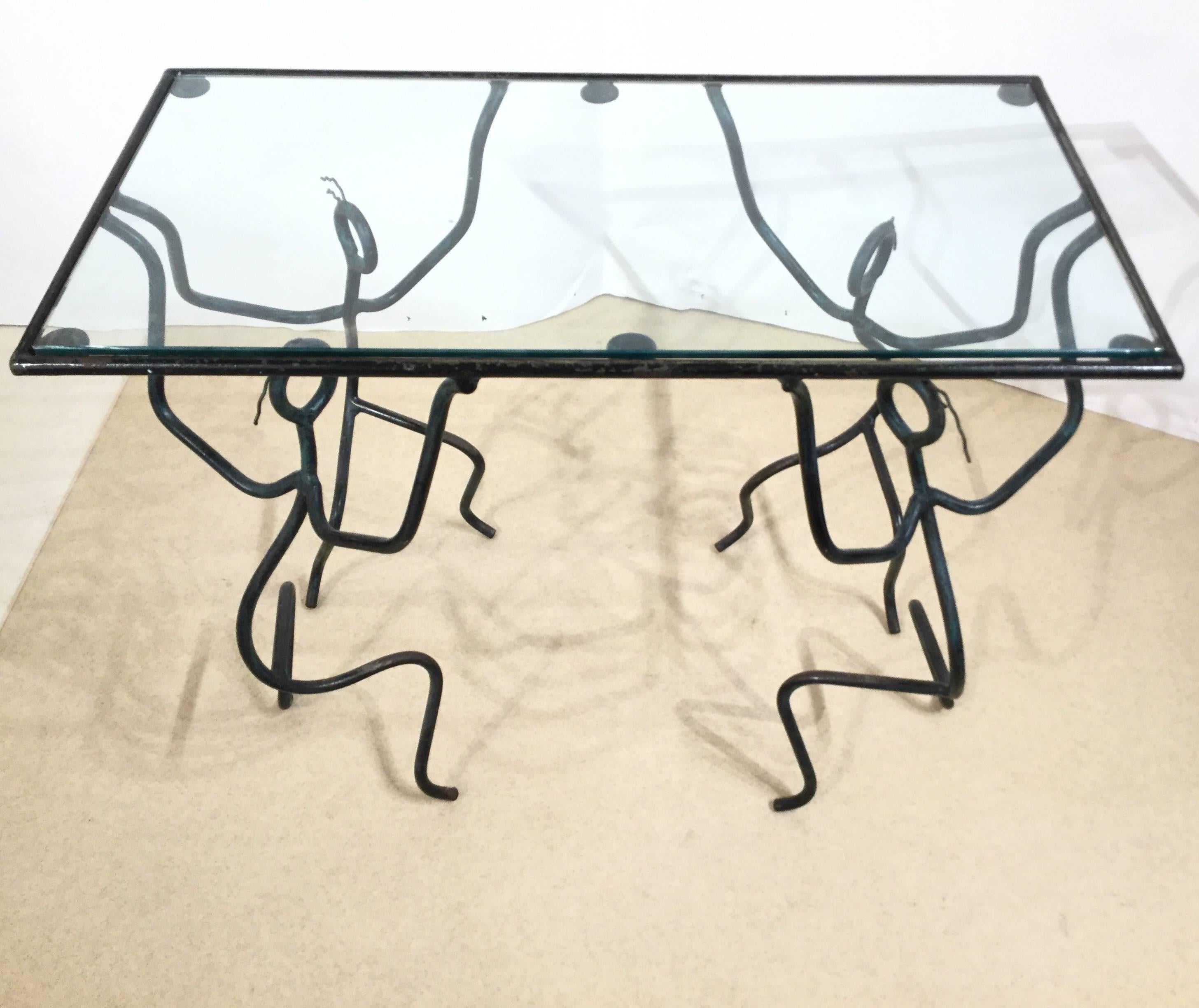 A beautiful coffee table in Iron. Four stylised iron men hold the glass top.
In good vintage condition.