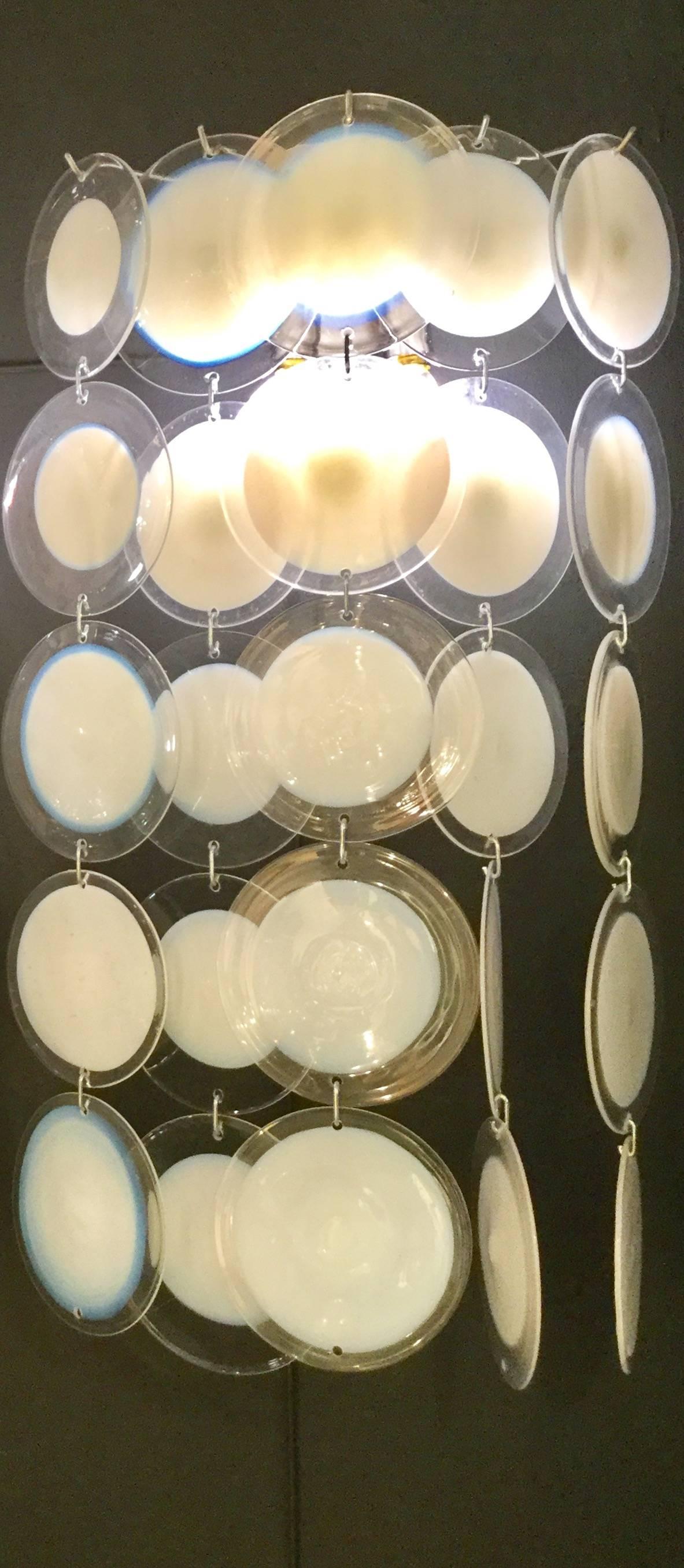 A pair of wall sconces composed of five lines of pending round clear Venetian glass pieces with a white centre. The glasses are put together using small hooks.
In excellent condition.