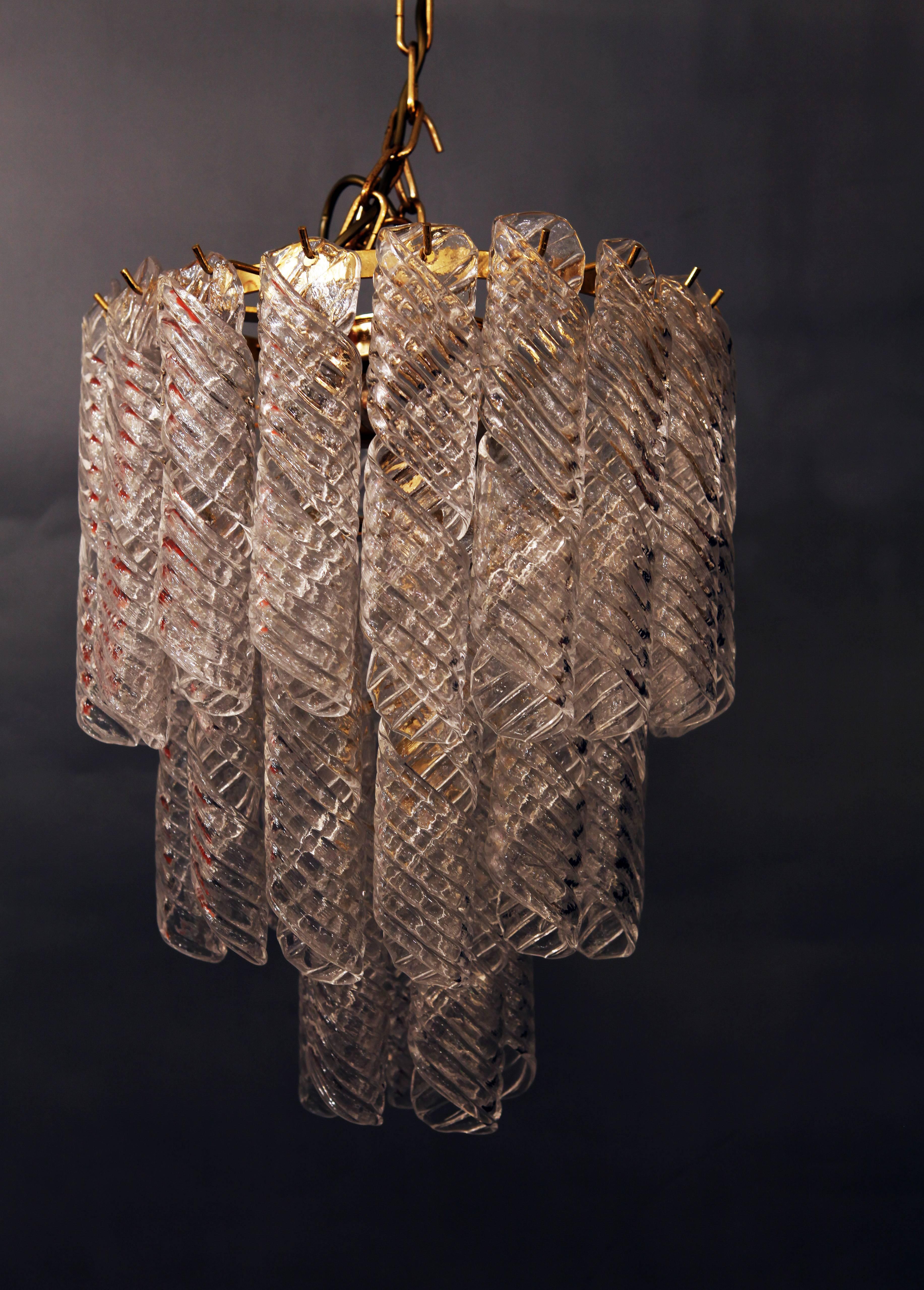 A stunning Italian chandelier made out of 36 pieces of twisted clear Murano glass hanging on a brass fixture.