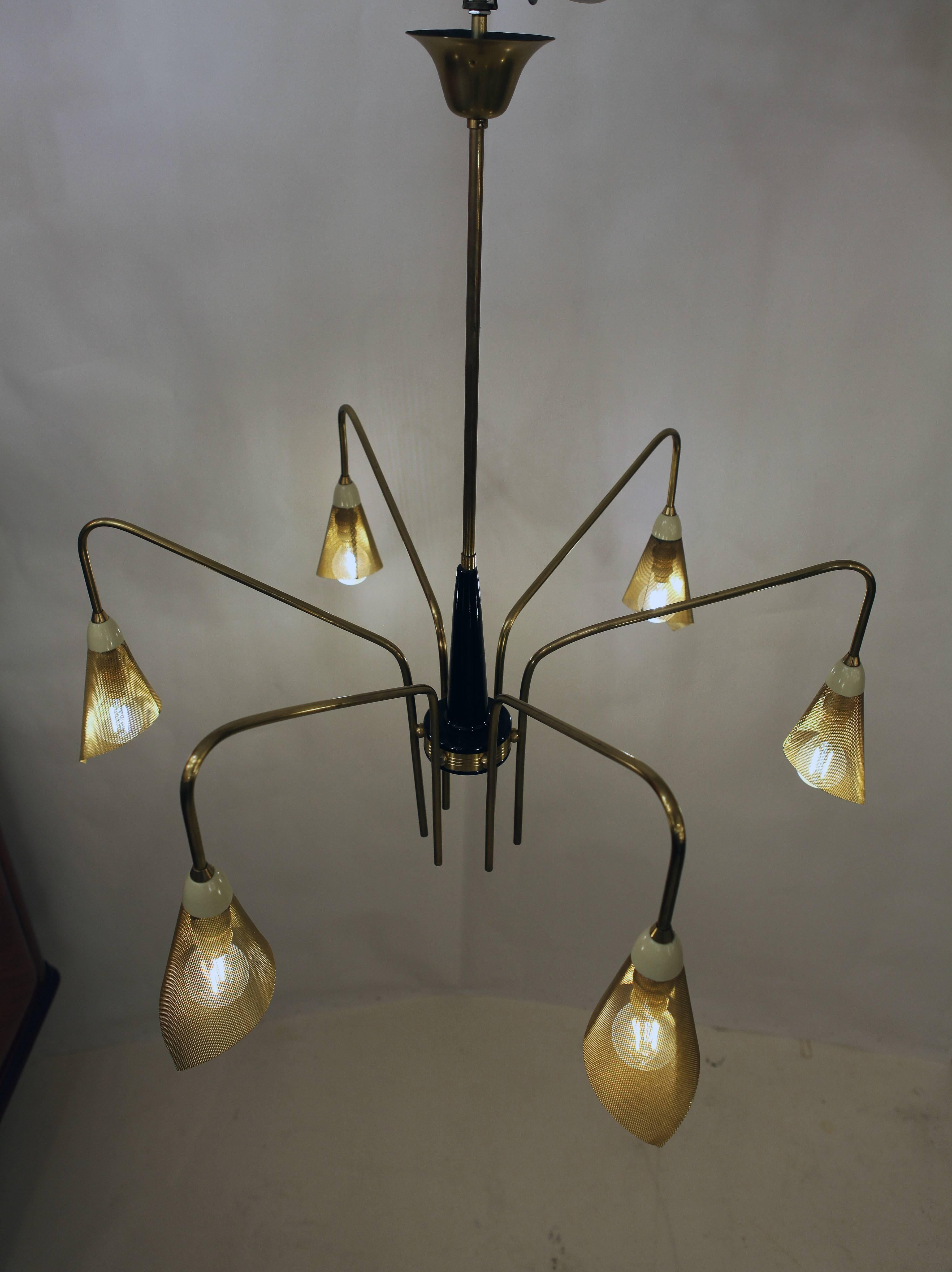An Italian chandelier in brass with five arms, the shades are in mesh metal which diffuses the lights.