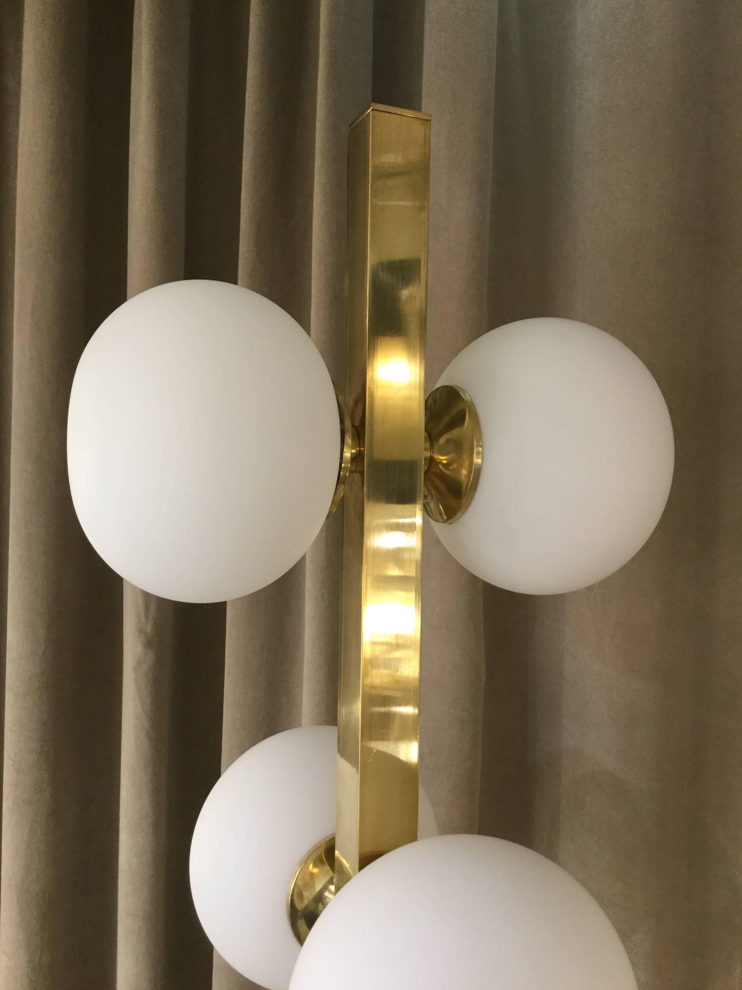 An Italian designed modernist floor lamp with ten spherical glass shade on brass structure In the style of Stilnovo.