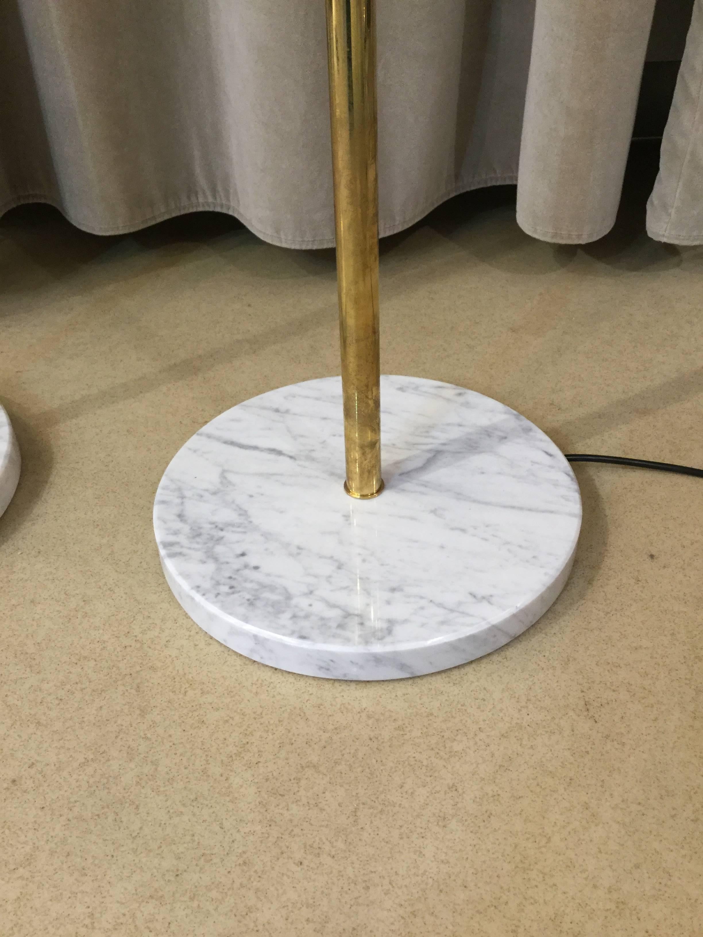 A pair of Italian modernist floor lamps brass with three uplighter shades painted Ivory and black over aluminium on circular Carrara marble bases in the style of Stilnovo.



 
