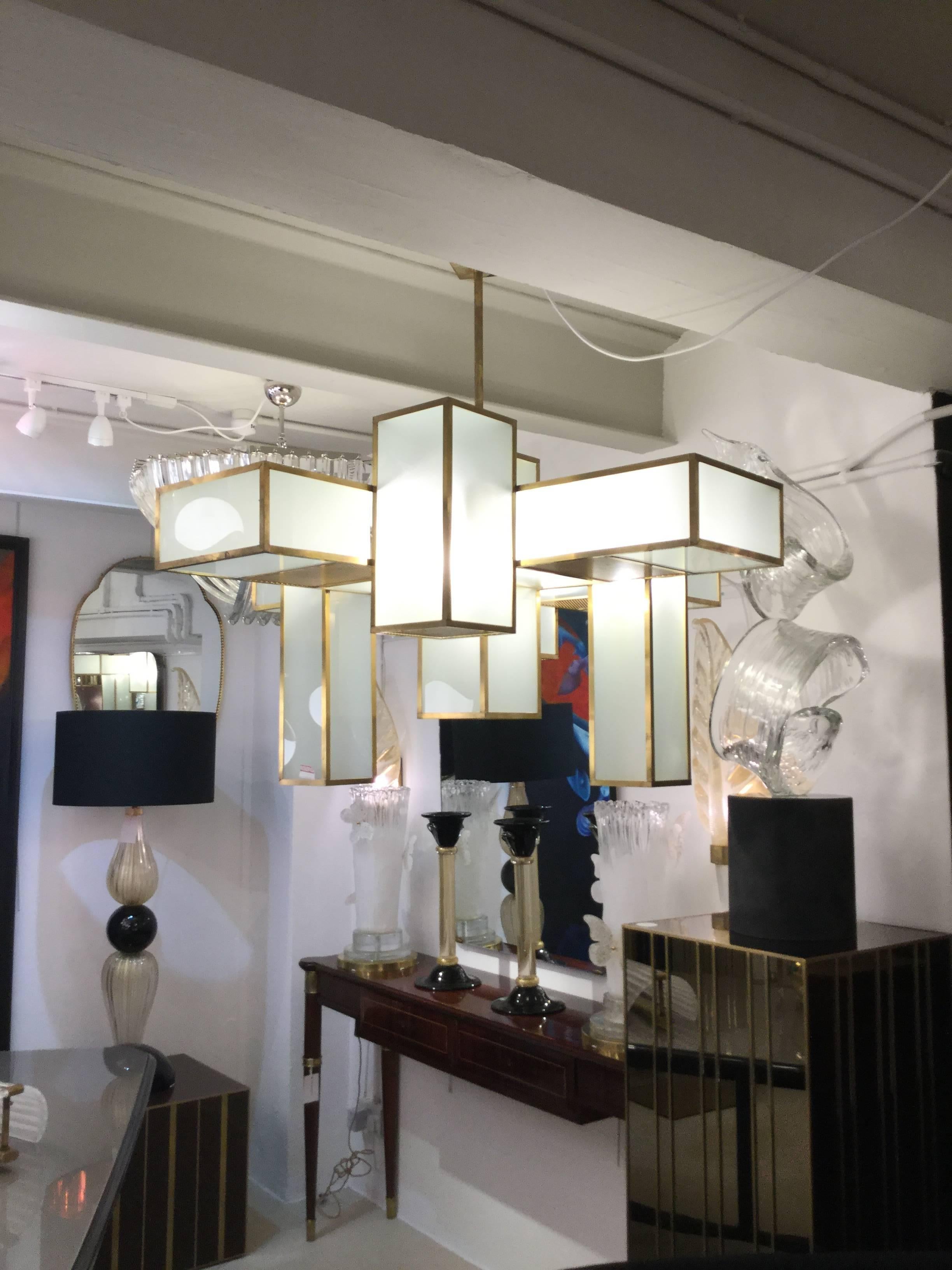 A pair of Italian designed modernist chandeliers "Sky Scraper" brass with glass.