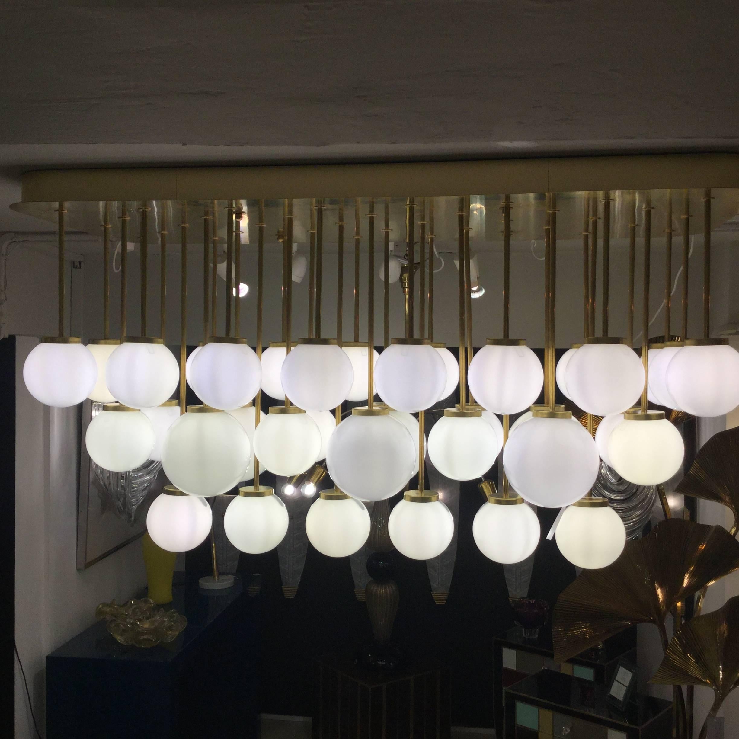 An Italian modernist chandelier in brass with 38 opaline spherical shades.