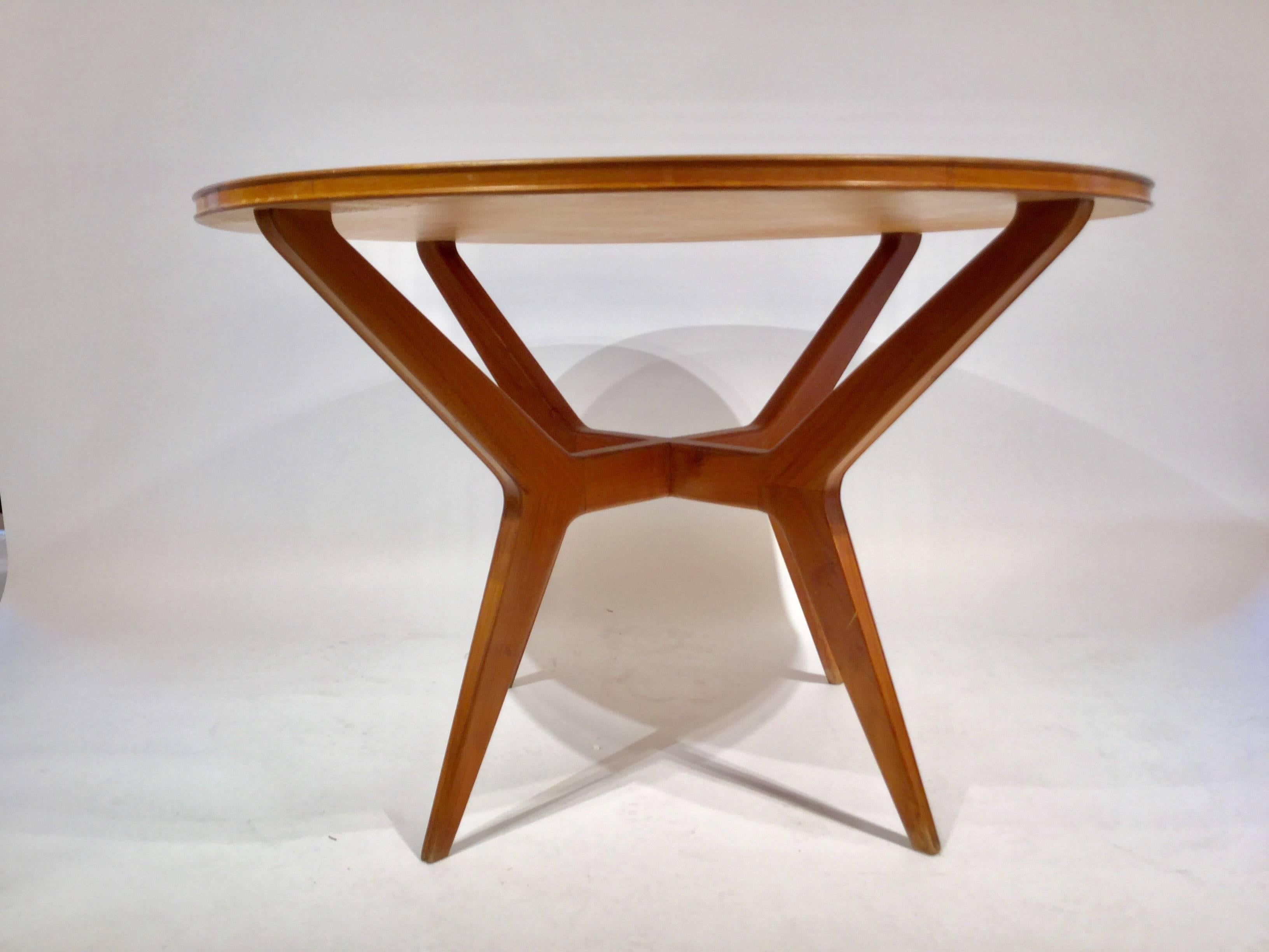 An Italian designed dining table in light walnut with inlaid glass top on sculptural legs attributed to Ico Parisi, circa 1950.