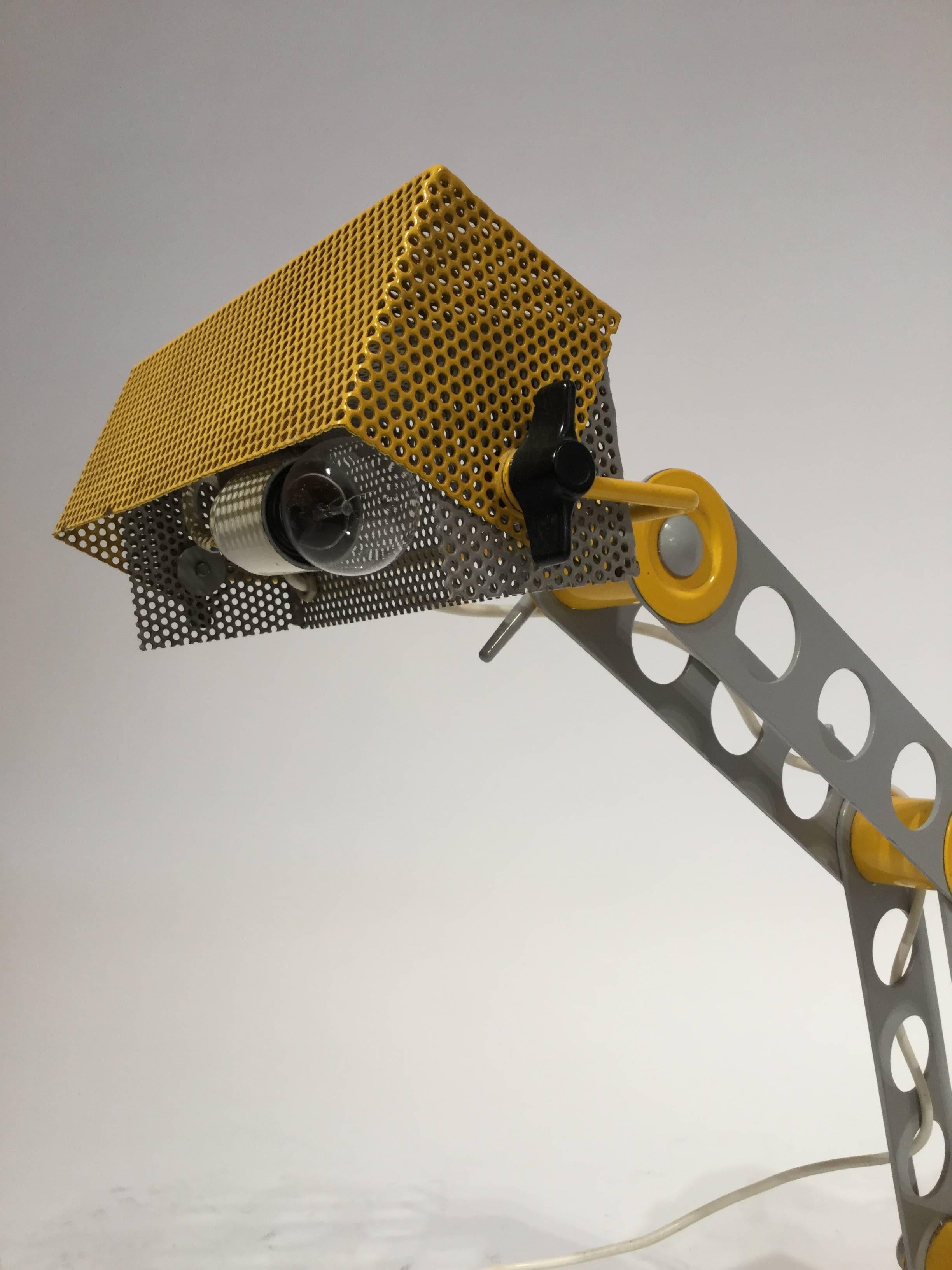 An Italian designed table or desk lamp post modern in the style of Ettore Sottsass in steel with perforated yellow shade in the bright Memphis colors, 1980.