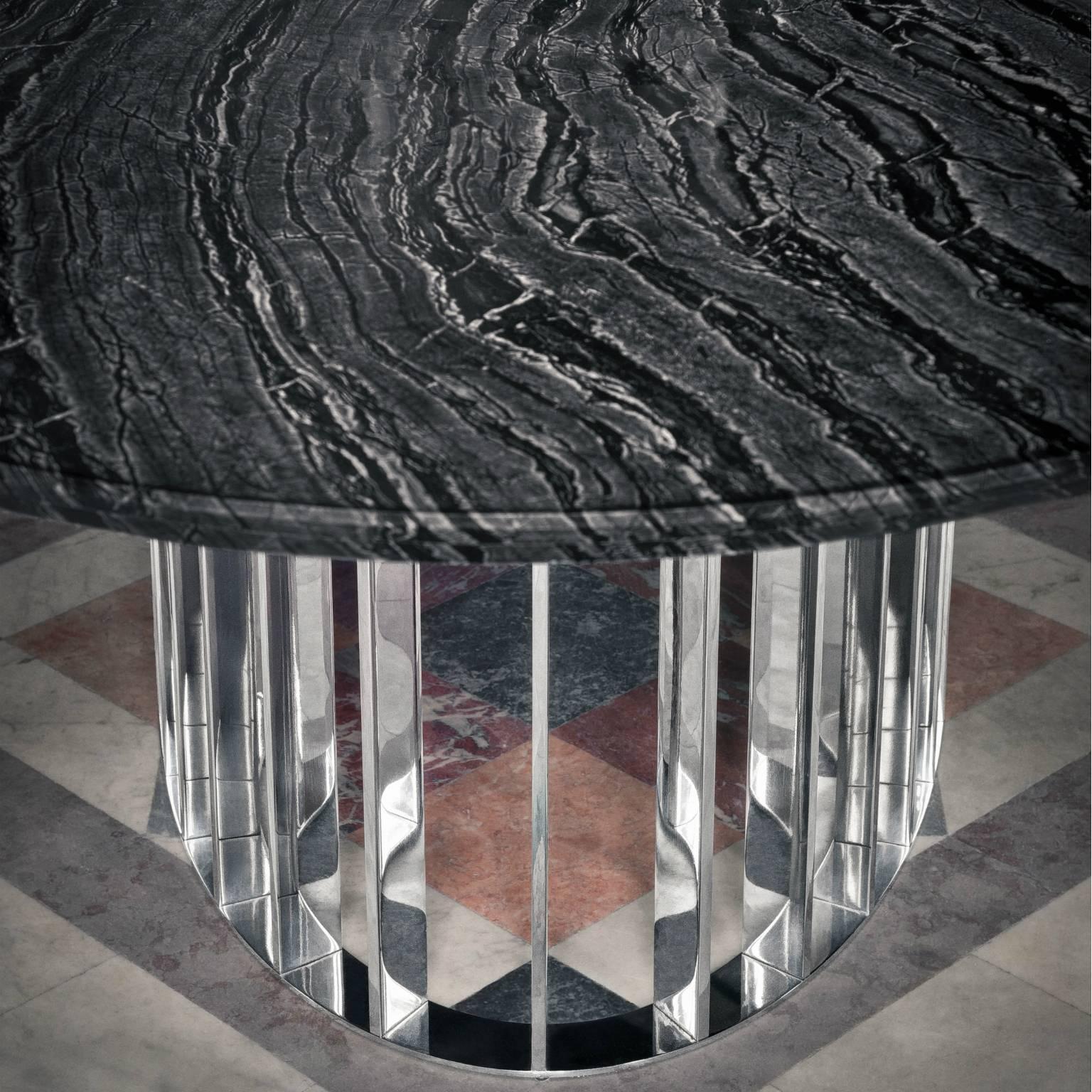 The OH table’s oval shape, available in different dimensions in order to be adaptable to the needs of each space, becomes the ideal canvas to showcase the marble’s rich veins, deep texture and smooth finish. The metallic element of the base