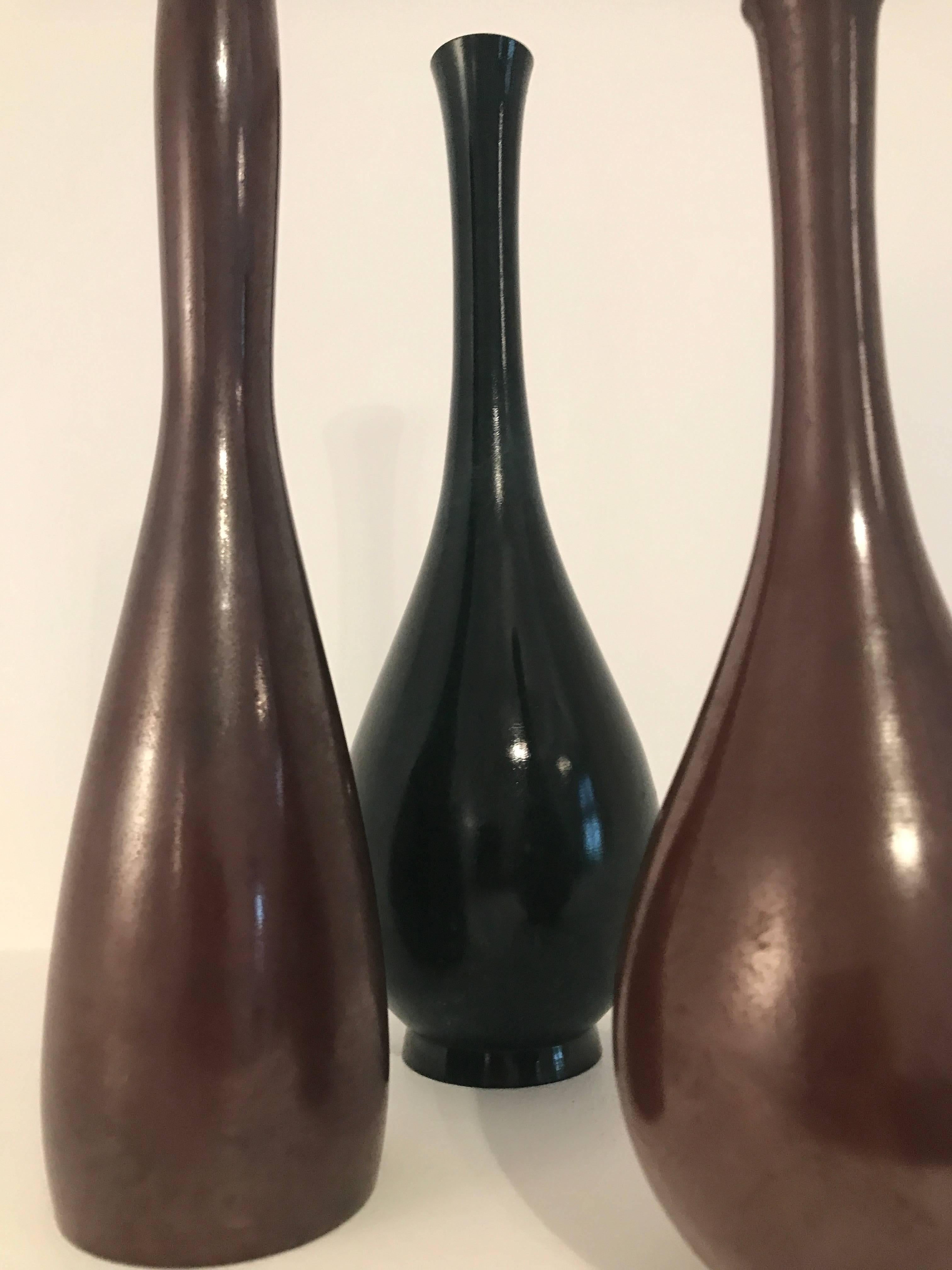 Ensemble de trois vases japonais en bronze.
Mesures : 
hauteur 27 cm diamètre 9 cm
hauteur 27 cm diamètre 7 cm
hauteur 21 cm diamètre 7 cm.
 