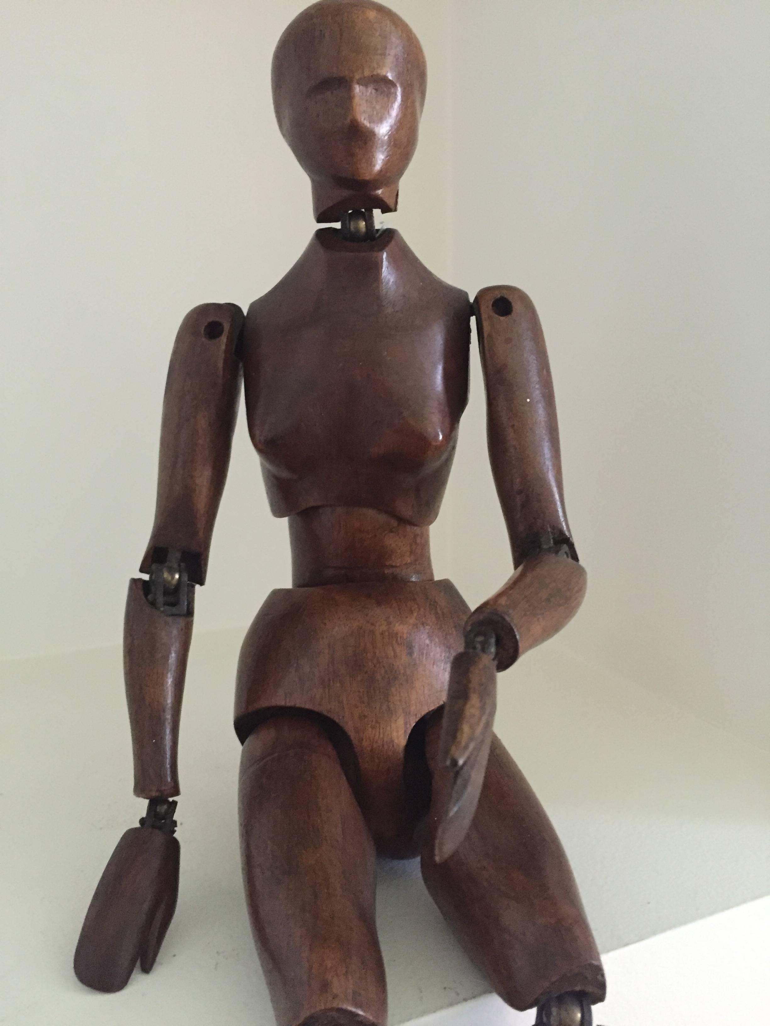 Unusual 19th century carved and stained wooden female figure with stylized head and articulated joints.