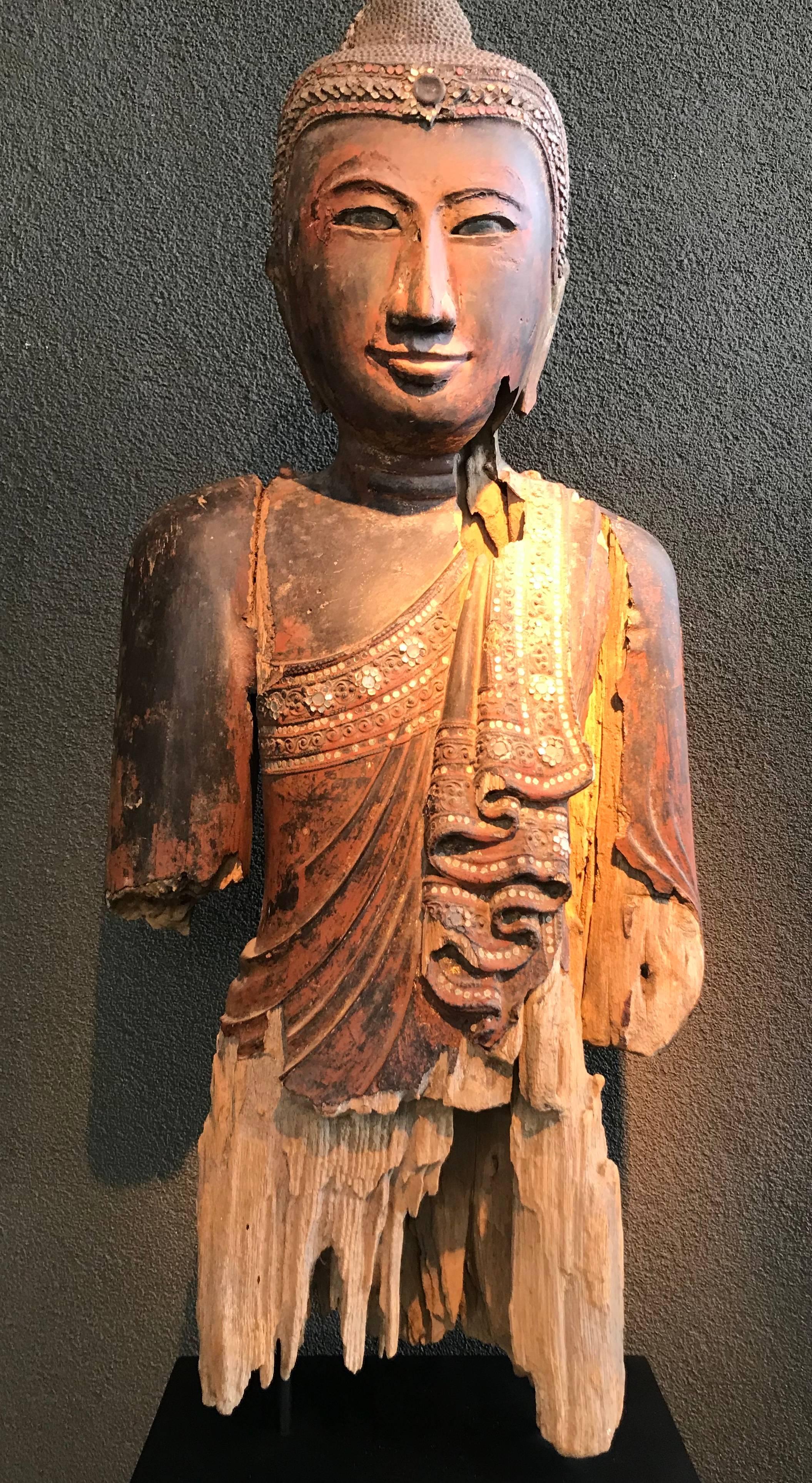 Thai wooden Buddha head, carved with polychrome traces, 19th century
part of a standing Buddha
decorated with glass elements.