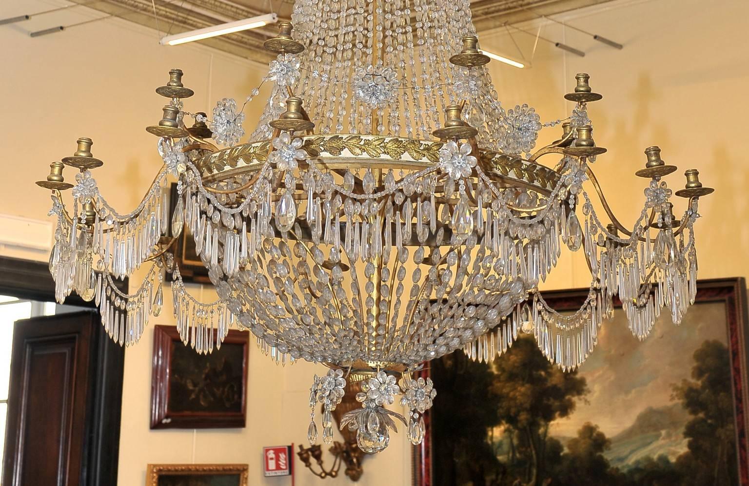 Louis XVI chandelier in gilded metal plate and cut crystal with 24 lights on two orders. Top-shaped balloon and decorated with golden palms - Genoa late 18th-early 19th century.