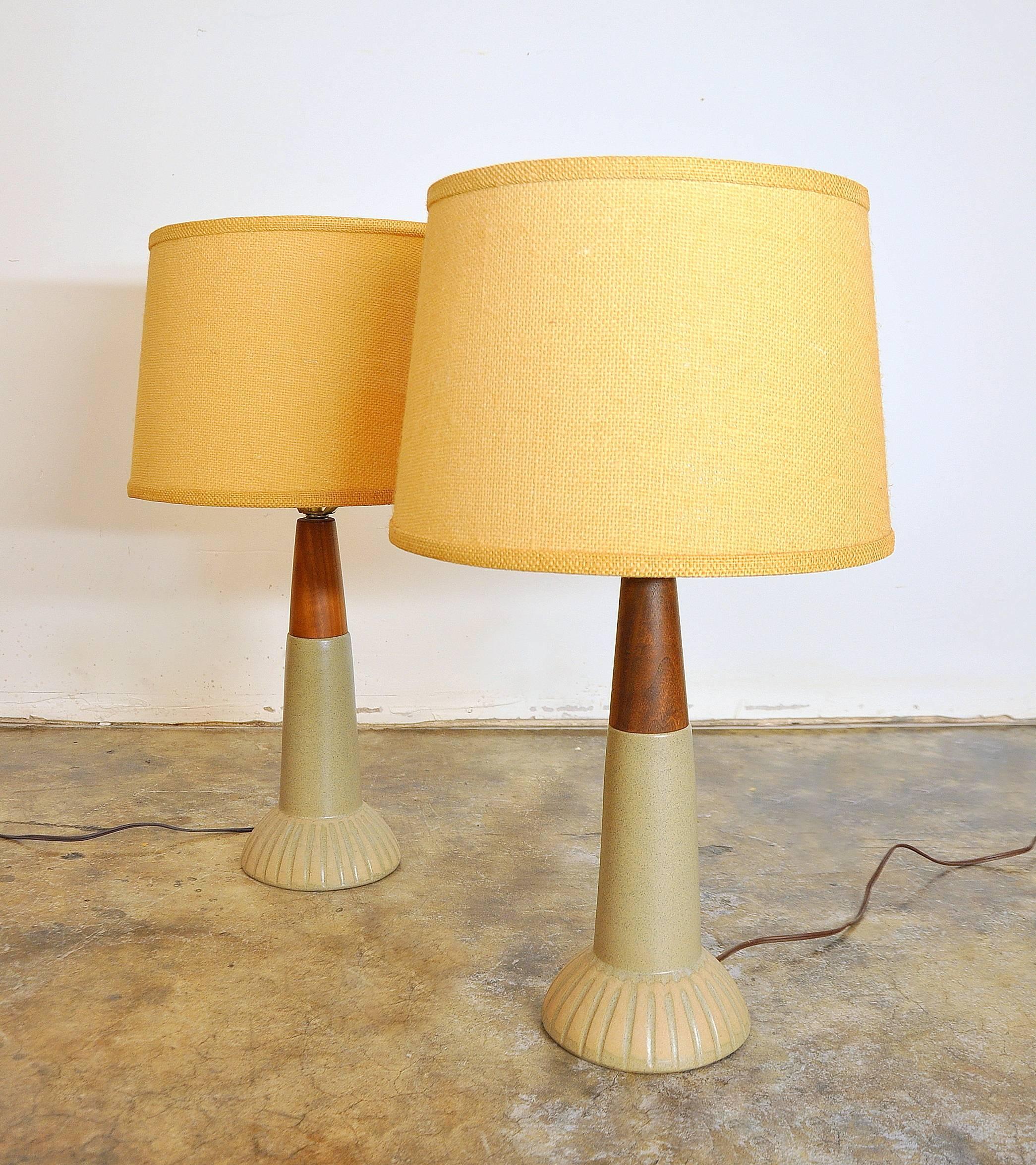 Stylish mid-century modern studio pottery glazed ceramic table lamps with unglazed linear accented saucer shaped bases, in typical Martz fashion. The hand speckled signature stoneware finish meets exquisitely sculpted walnut necks with a glistening