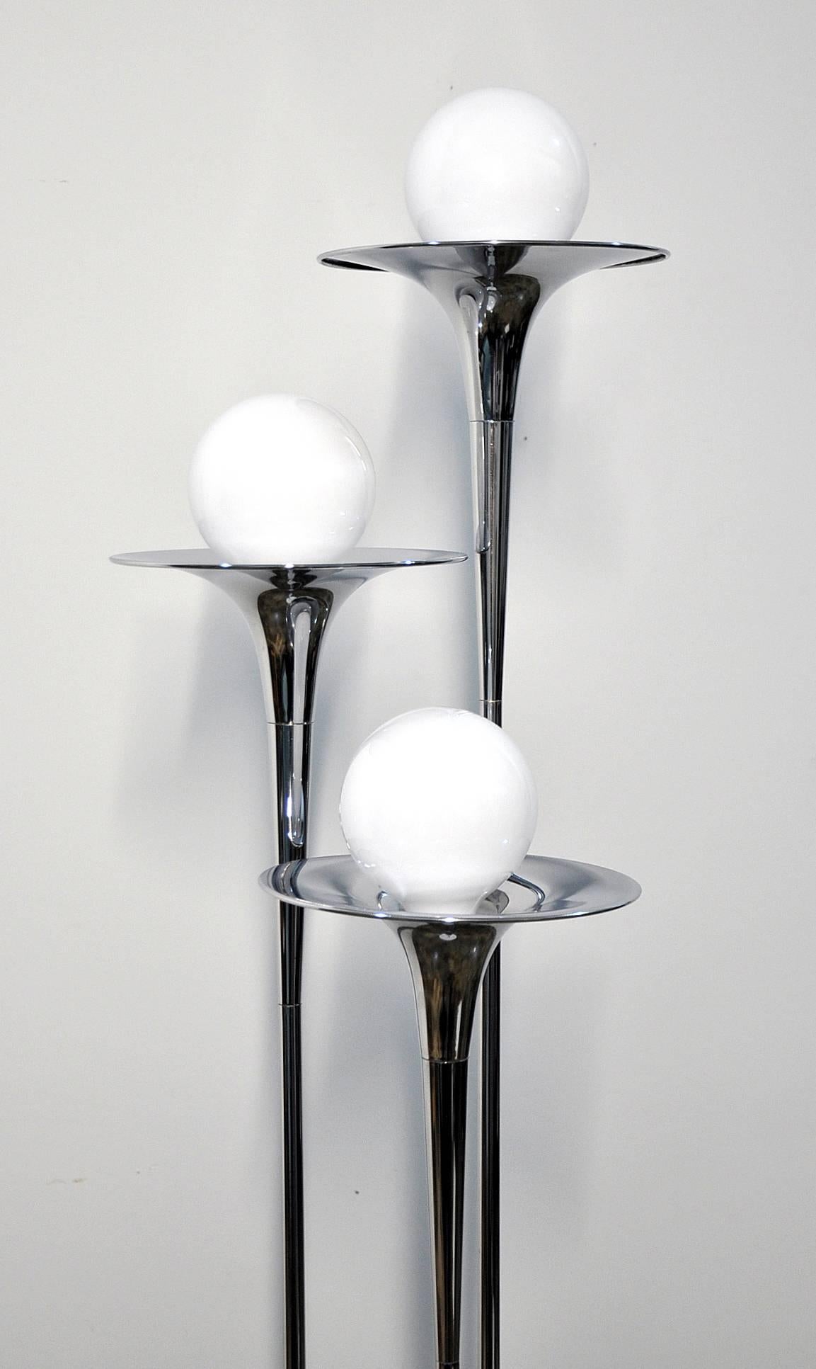 Gorgeous polished chrome vintage floor lamp with three trumpet shaped shafts and white enameled base, dating from the 1970s. Easily turns on and off with a slight push of the foot as switch is located on the base. Sleek and stylish design that not