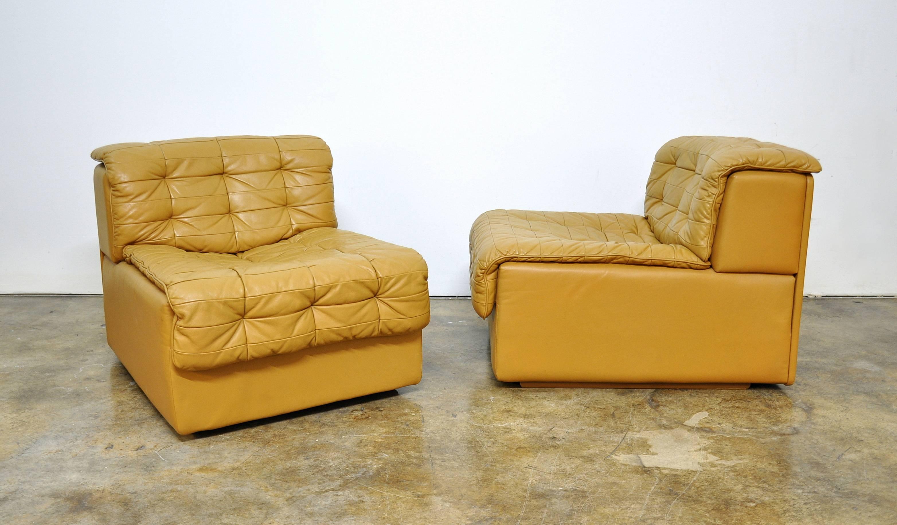 Pair of Italian Modern style soft caramel patchwork Chesterfield leather slipper or occasional chairs manufactured by De Sede of Switzerland in the 1970s and imported by Turner, New York. The chairs feature a modular design and can be used together