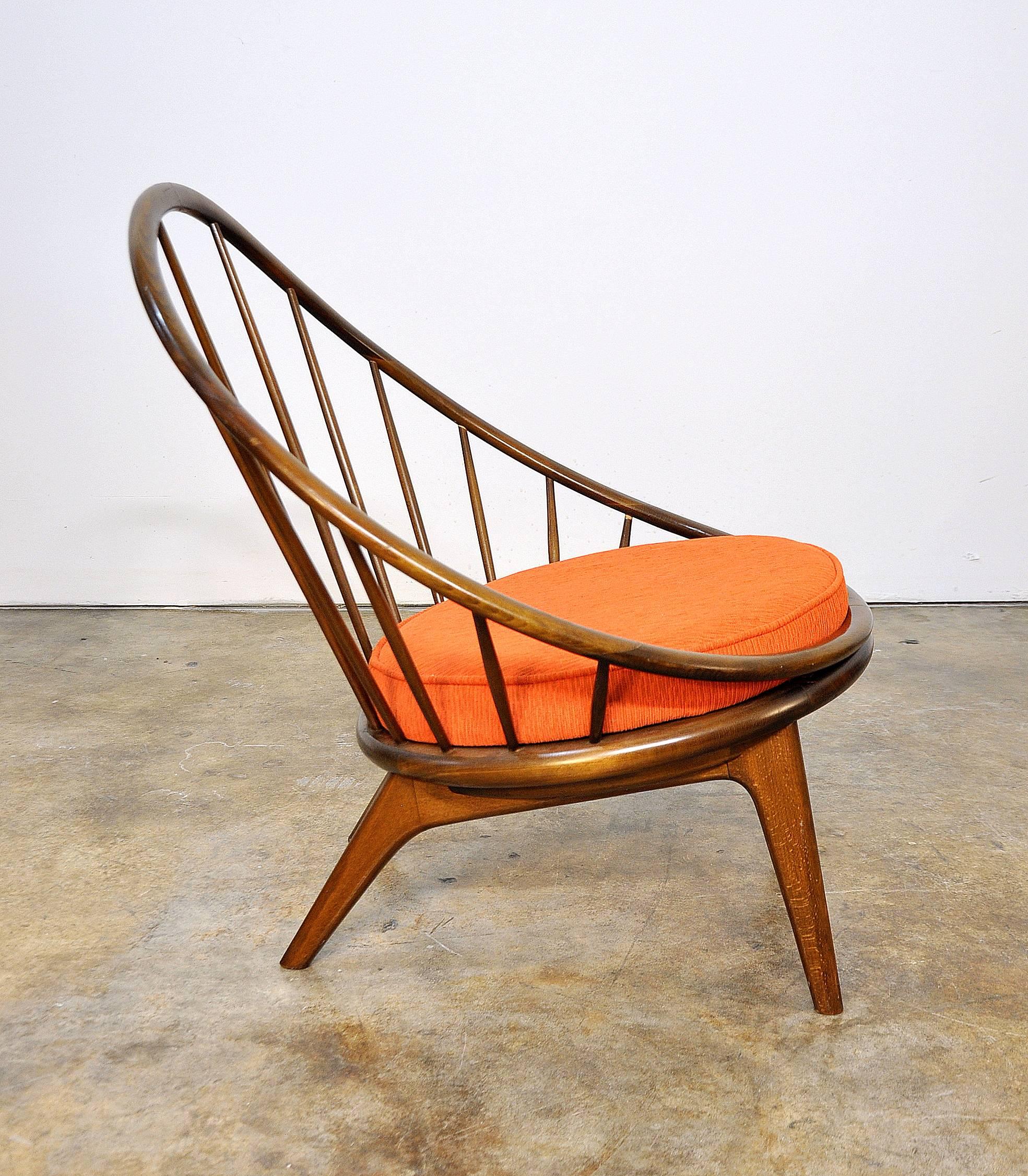 This is a rare and early example of Kofod Larsen's hoop chair, dating from the late 1950s. He later modified the design of the chair by adding batwings on the arms. The redesigned chairs were distributed by Selig in the early 1960s. The chair