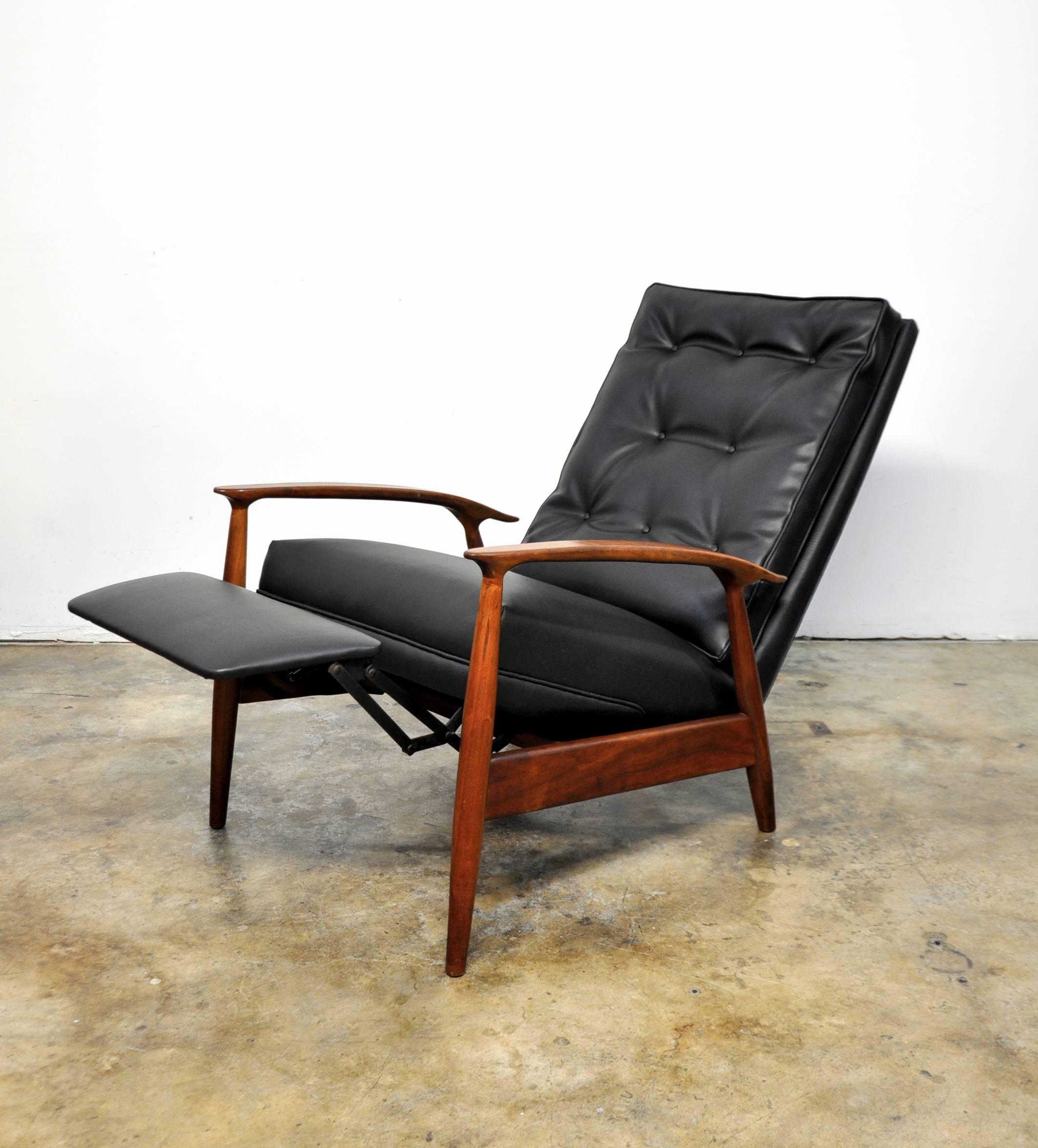 This early example of Milo Baughman's Mid-Century Modern reclining lounge chair dates from the 1950s. It features an amazing, sculptural solid walnut frame that displays beautiful grain. The chair has a tufted back cushion and is very comfortable,