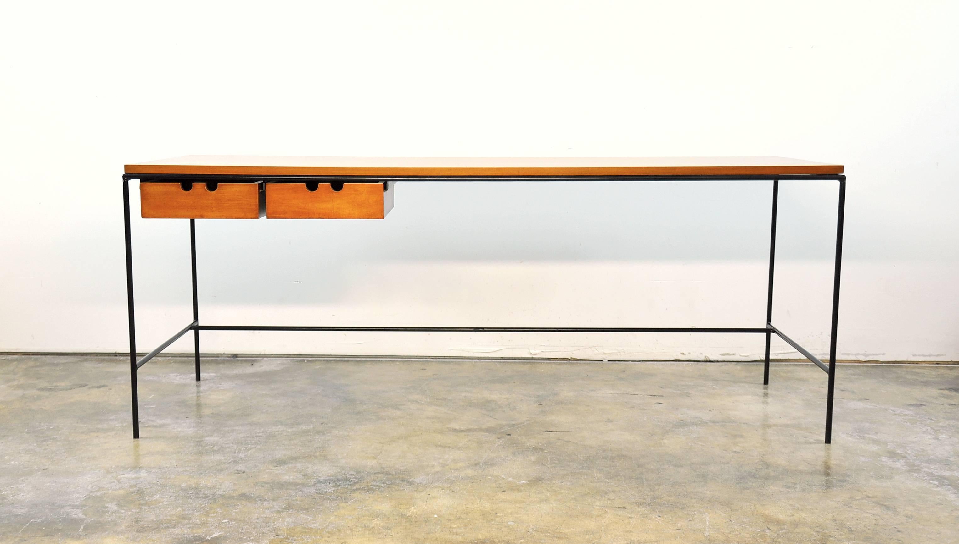 Elegant and minimalist Mid-Century Modern cocktail or sofa table designed by Paul McCobb for Winchendon Furniture in the 1950s. The graceful black iron base is complemented by a pair of solid maple drawers. The simplicity of the table make it the