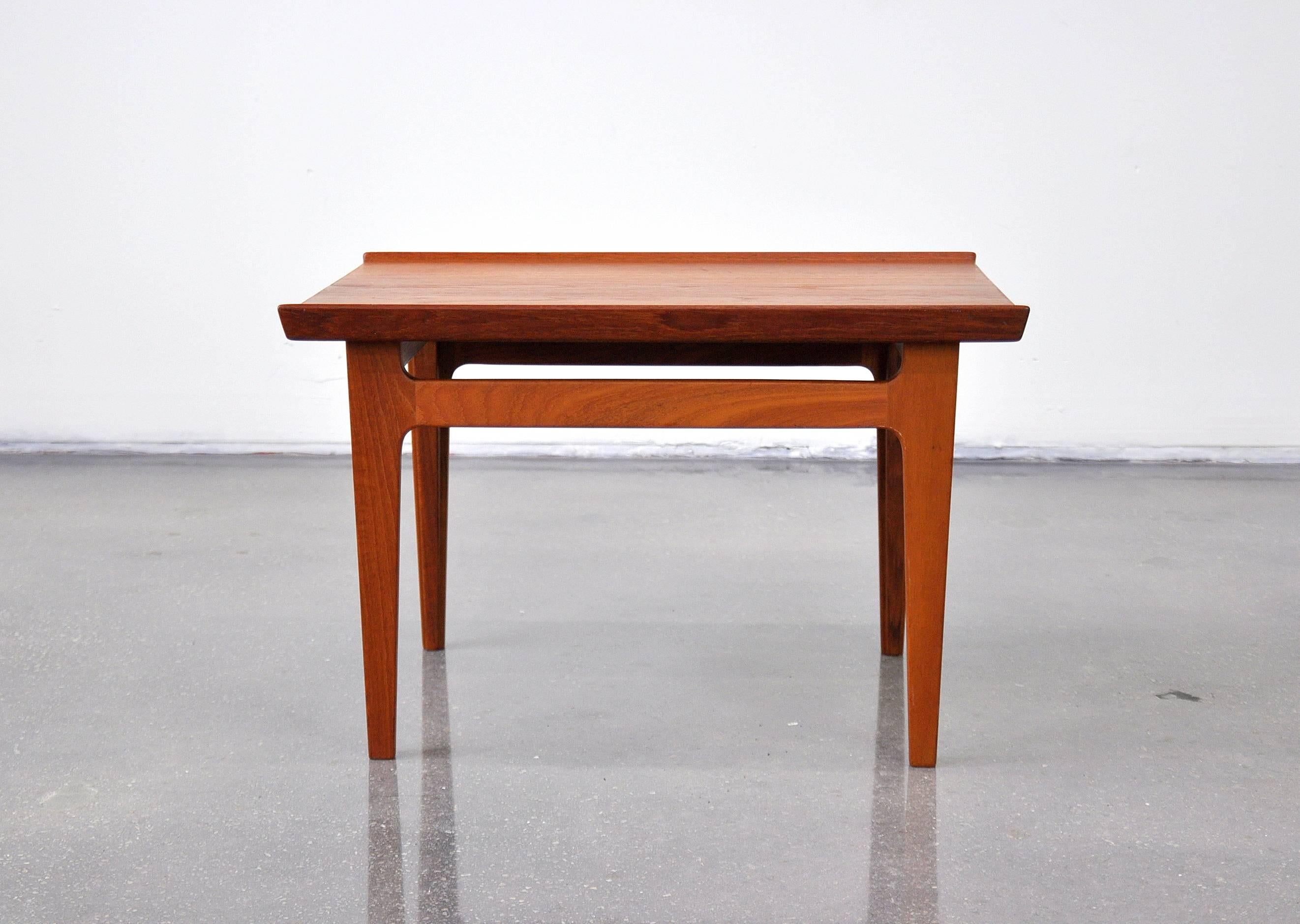 Solid teak Mid-Century Danish modern occasional table, model 535, designed by Finn Juhl for France and Daverkosen. The small end table features a raised lip and sculpted legs. In great original condition, it boasts a beautiful, warm patina. The