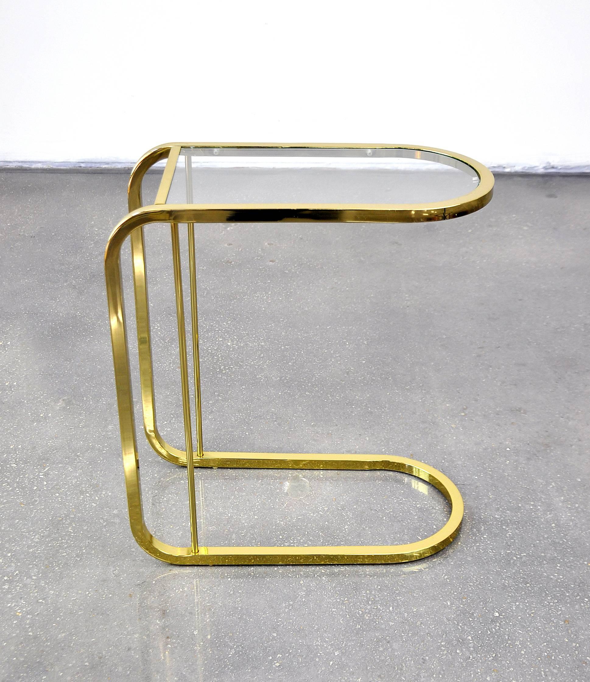 A pretty Mid-Century Modern brass end table of cantilever design with inset glass top, dating from the 1970s, and reminiscent of designs by Milo Baughman for D.I.A. (Design Institute of America) and Thayer Coggin. Its smart design allows the accent