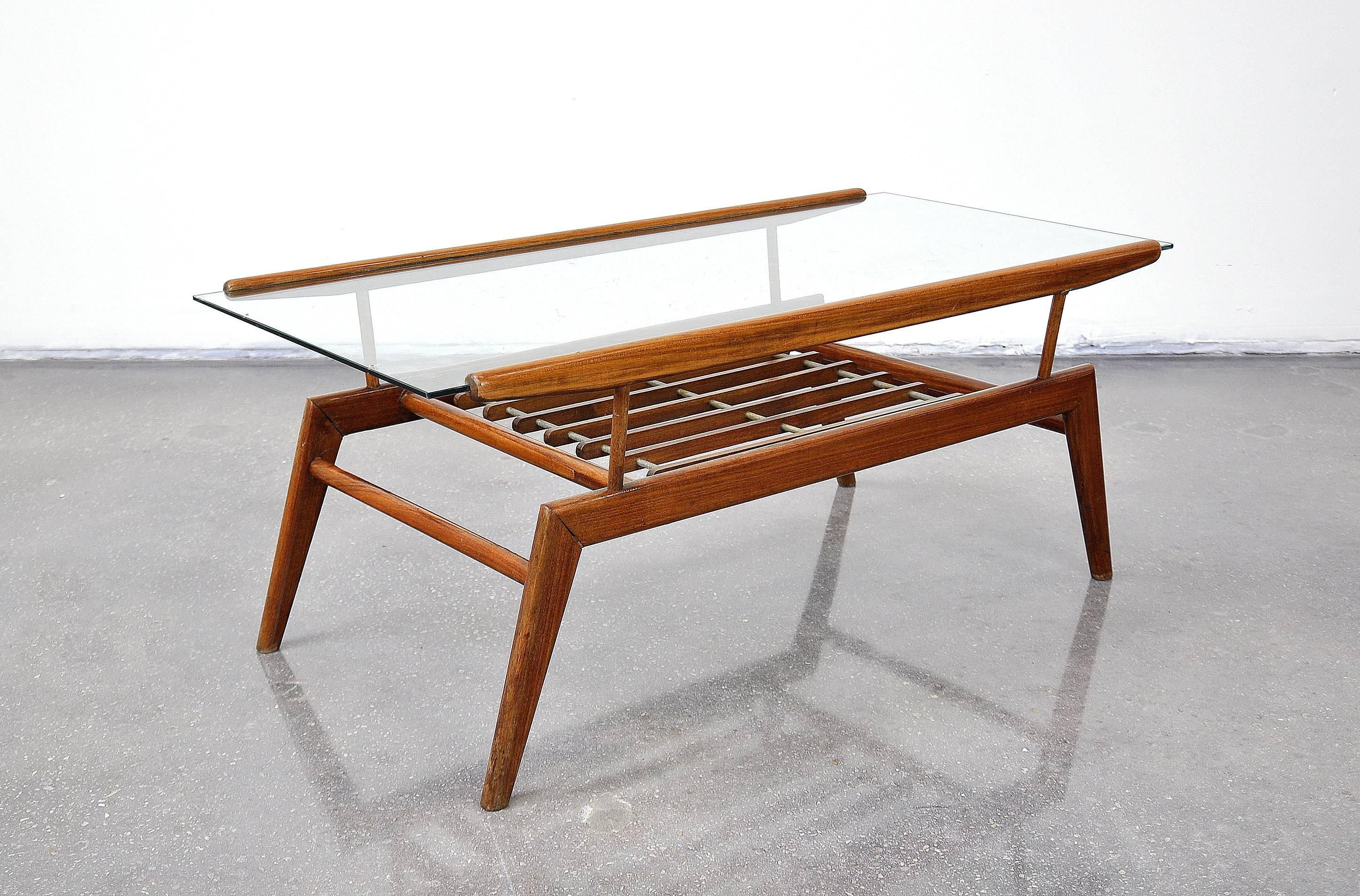 An early Italian Mid-Century Modern walnut and glass cocktail table, in the manner of Gio Ponti, dating from the late 1940s-early 1950s. The two-tier table features a striking architectural walnut frame with an inset glass top over a slatted