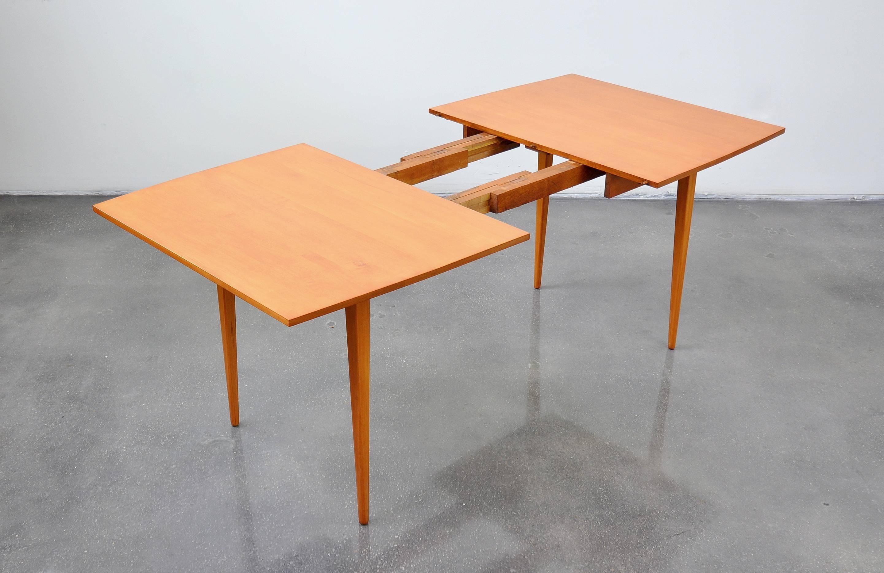 A beautiful Mid-Century Modern expandable dining table designed by Paul McCobb for the Perimeter Group line in circa 1957, and manufactured by Winchendon Furniture. The table is maple, with a boat-shaped top and elegant, simple, timeless lines. It