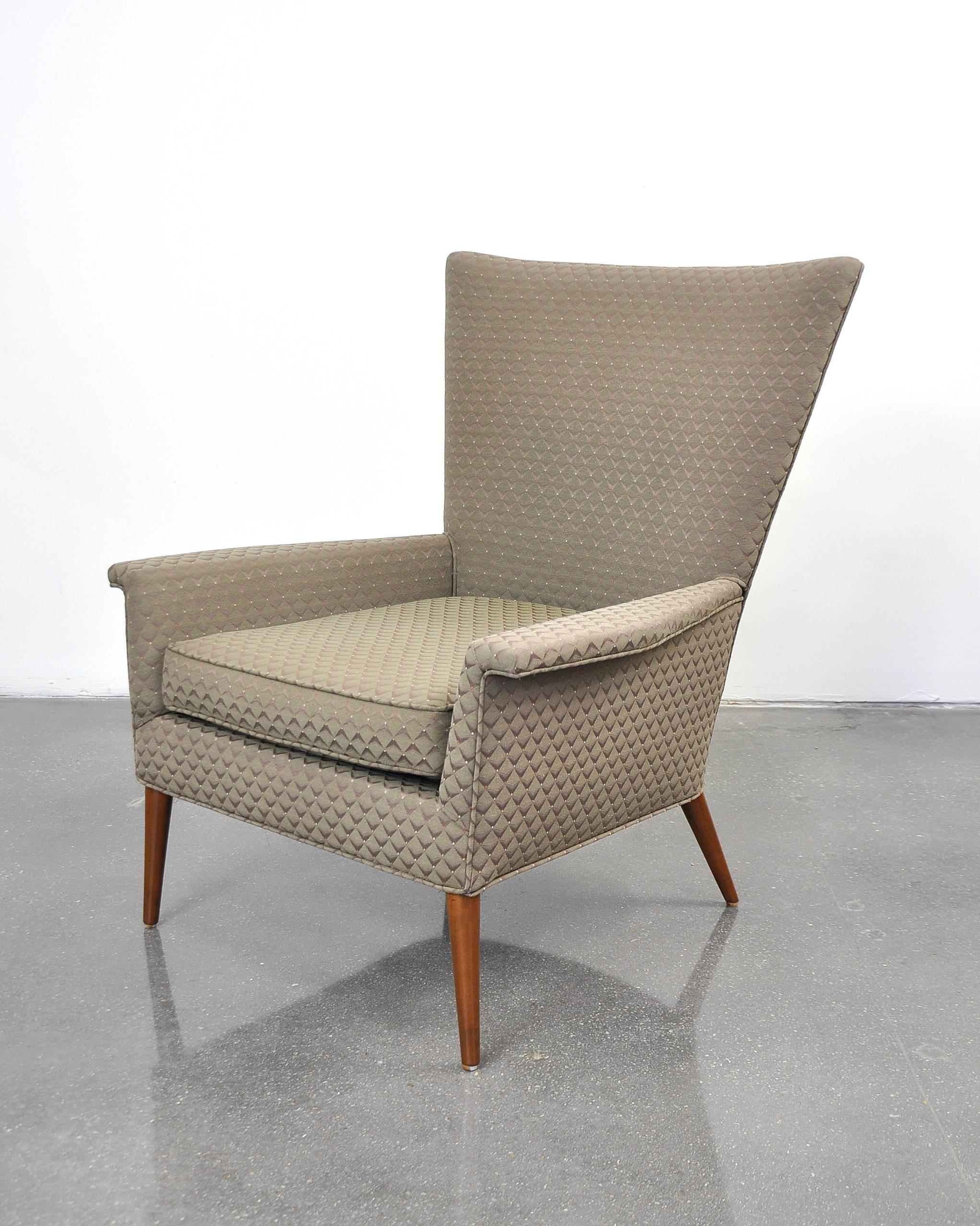 Rare Mid-Century Modern high back lounge armchair designed by Paul McCobb for the Planner Group line and first manufactured by Custom Craft in 1950. The armchair features a winged highback and sleek, splayed walnut legs. Retains original label.