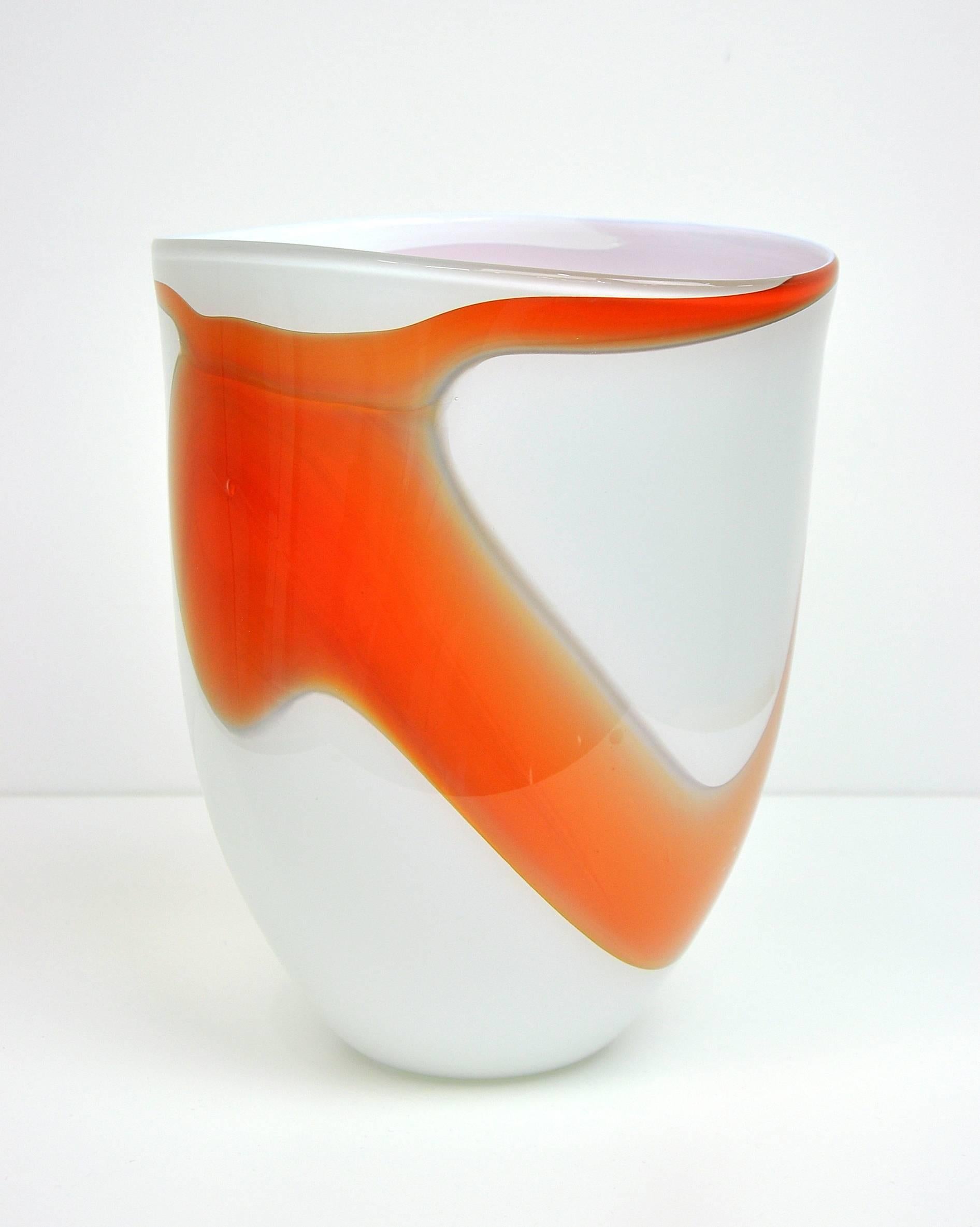 An early handblown glass vase by American artist Martin Blank (1962, WA). The blown glass vessel features a flattened bell shape decorated with vivid tangerine orange fluid-form decoration on an opaque, milky white background. Signed on