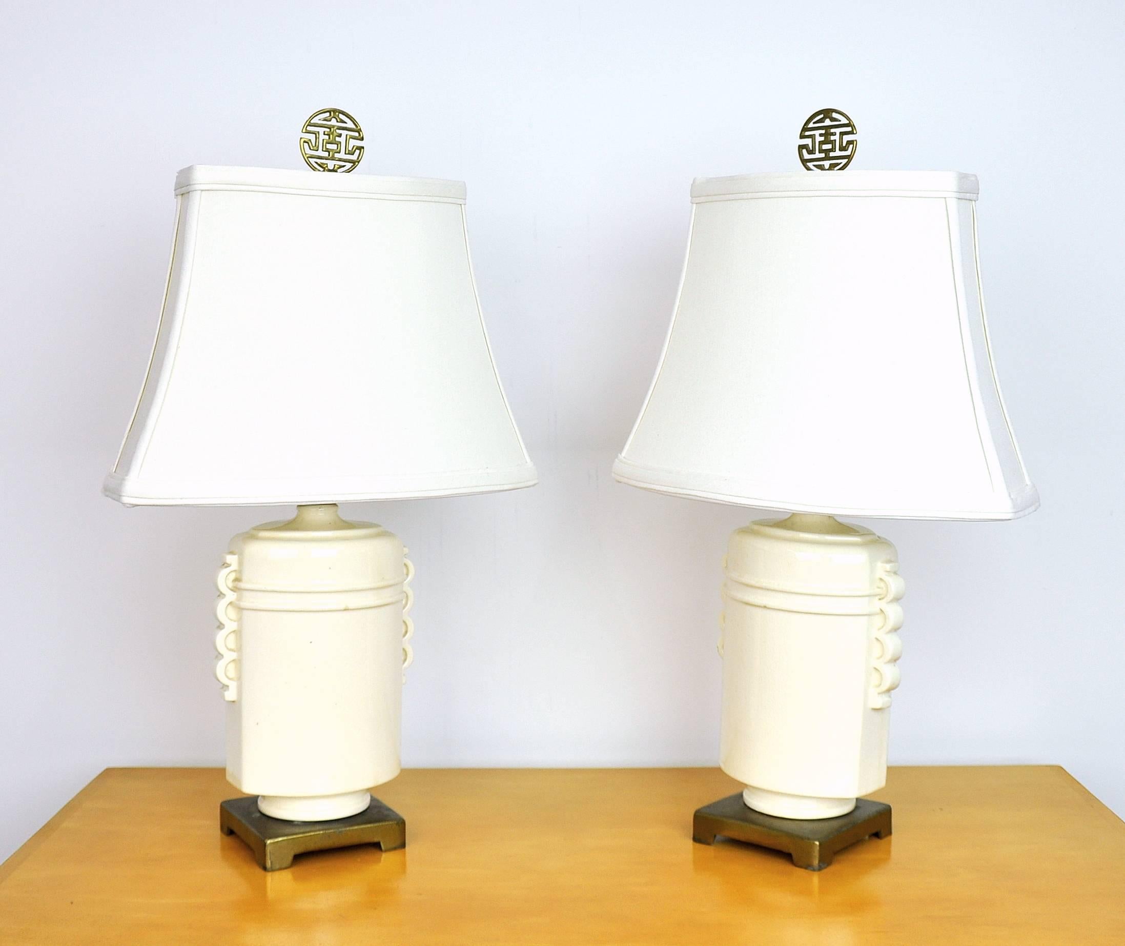 A vintage pair of creamy white porcelain table lamps with brass bases and finials, fitted with brand new shades. Perfect for nightstands or side / end tables. Finials feature chinoiserie motifs.