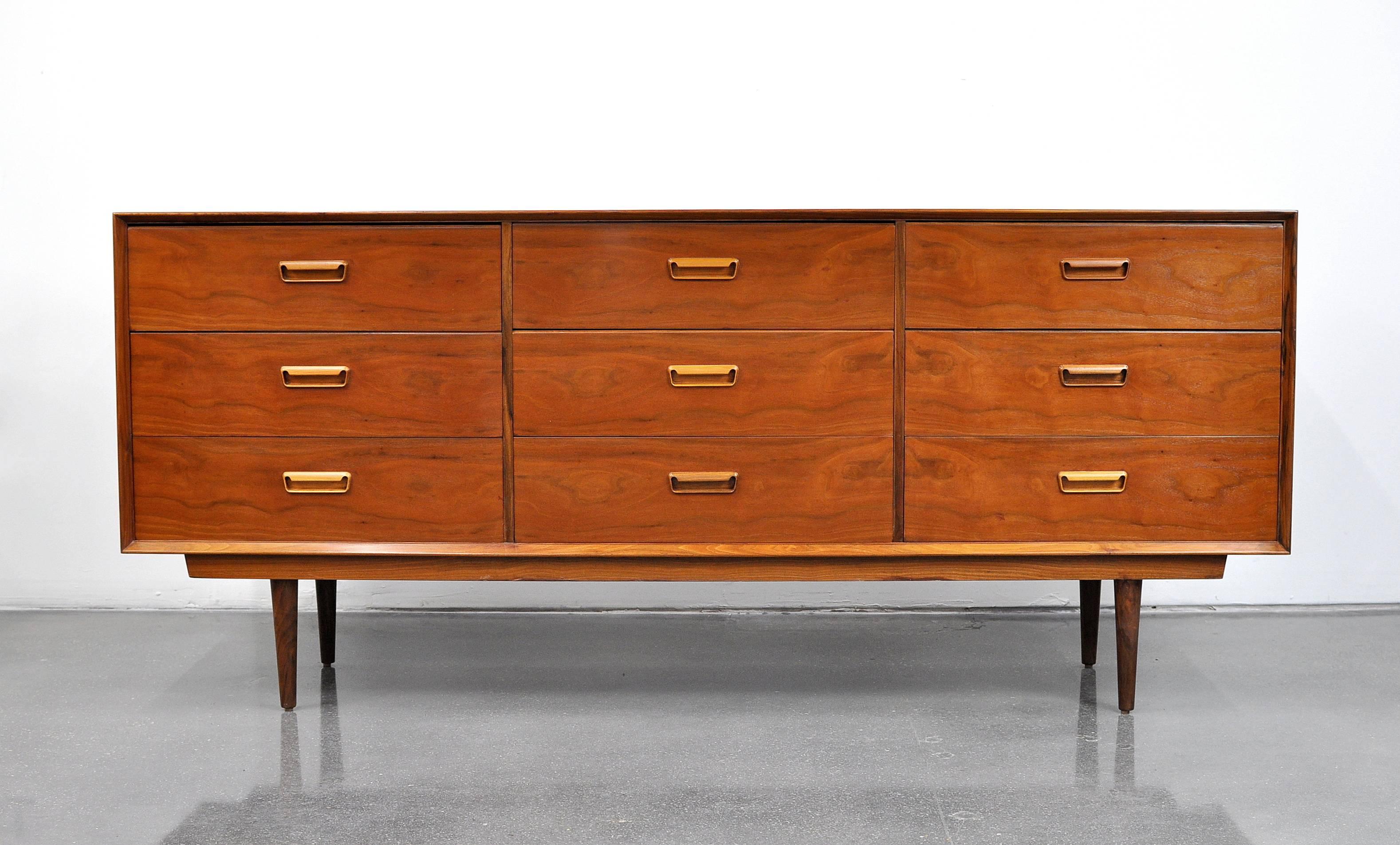 A stunning Mid-Century Danish Modern vintage rosewood credenza with finished back, designed by Arne Wahl Iversen, and dating from the 1960s. The dresser features nine drawers with mahogany interiors which provide ample storage space. Six of the