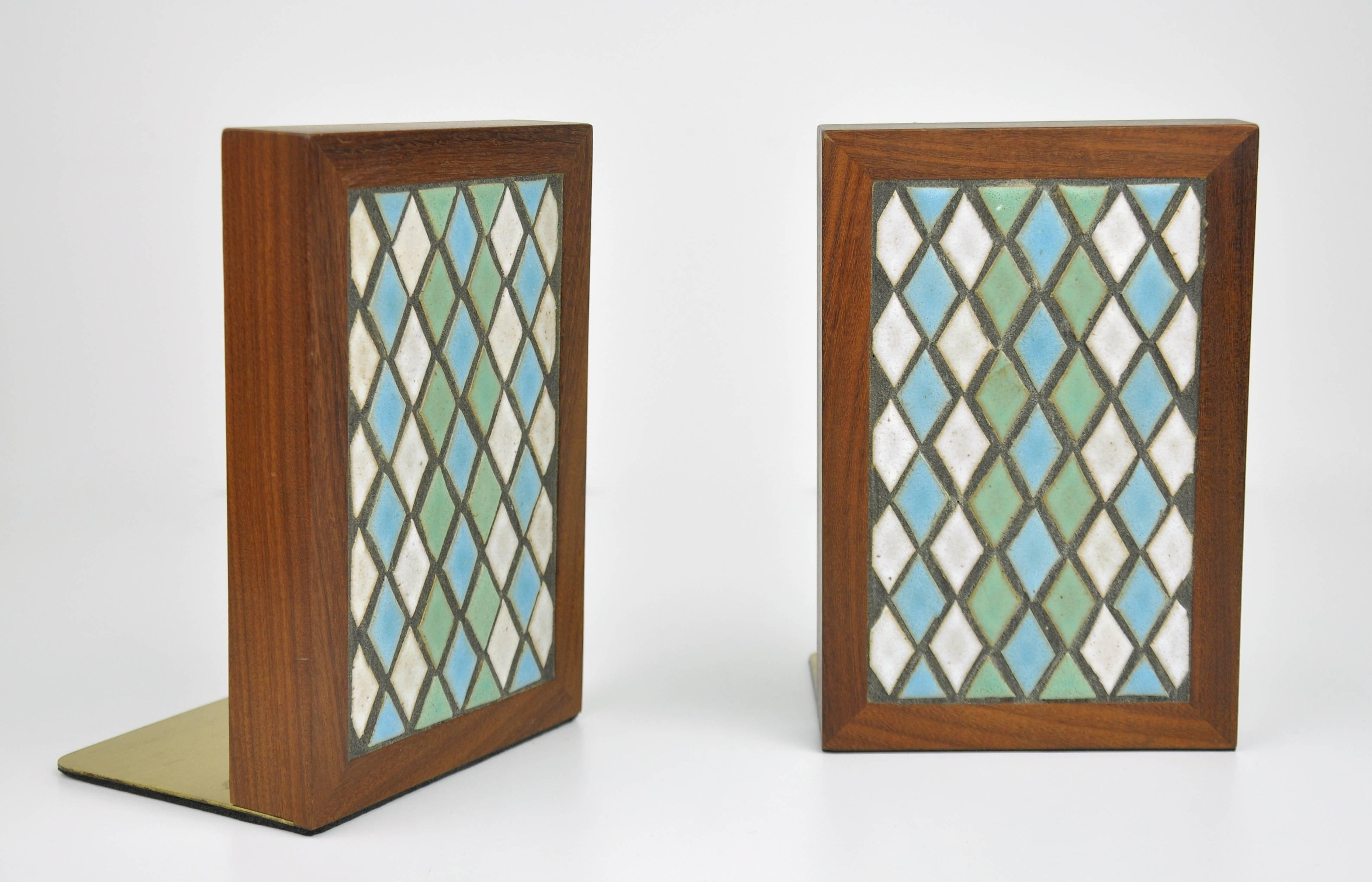 Colorful and decorative pair of Mid-Century Modern walnut, stoneware ceramic tile and brass model TBE1-21 book ends, dating from the late 1950s. The fronts feature a diamond pattern of turquoise / light blue, pastel green and off-white / cream tiles
