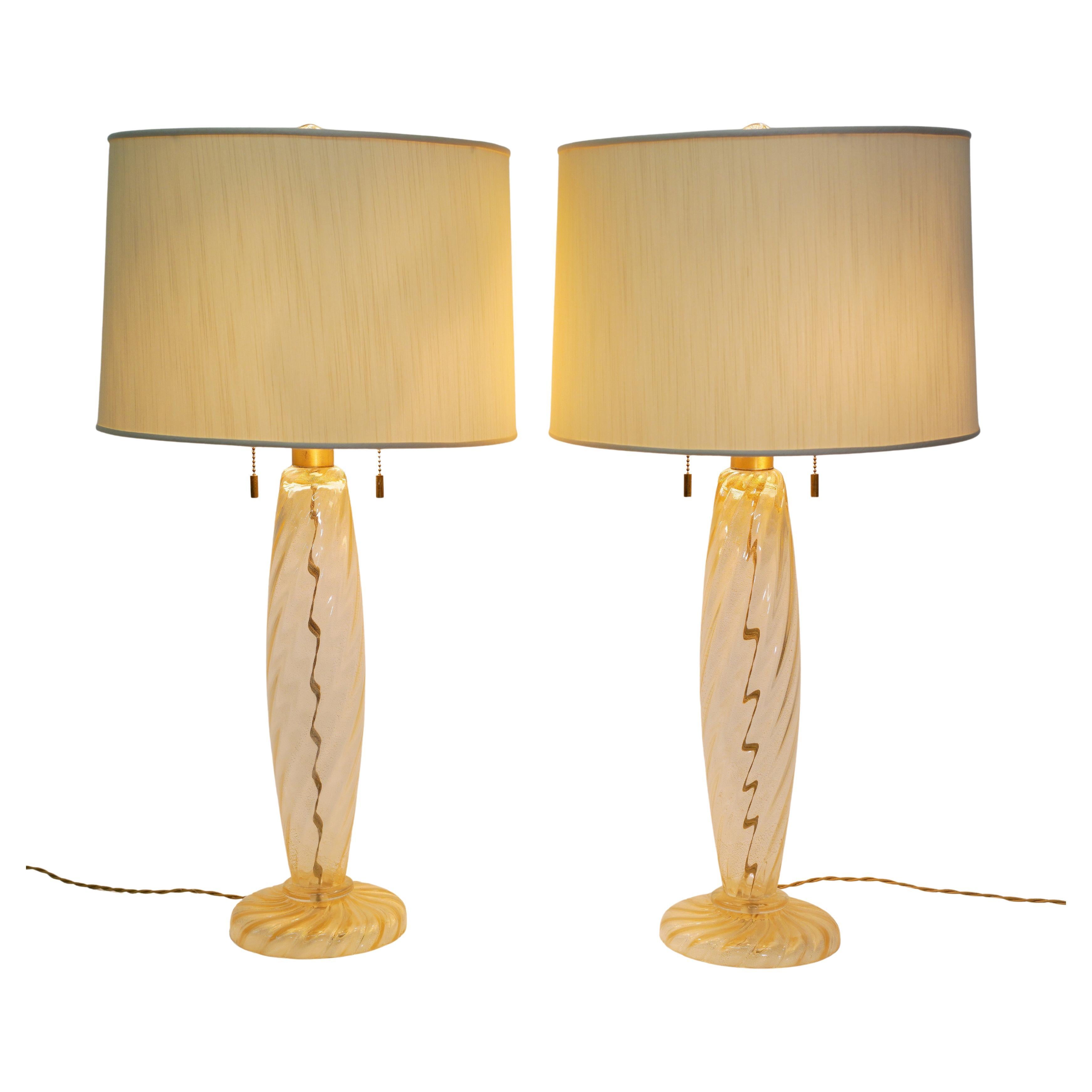 These stunning hand blown Seguso Murano lamps were made in the late 80's to early 90's for Donghia and were designed by John Hutton.
The Ondoso lamps are clear with gold dust and gold aventurine. They have 2 brass pull chains on each lamp and 2