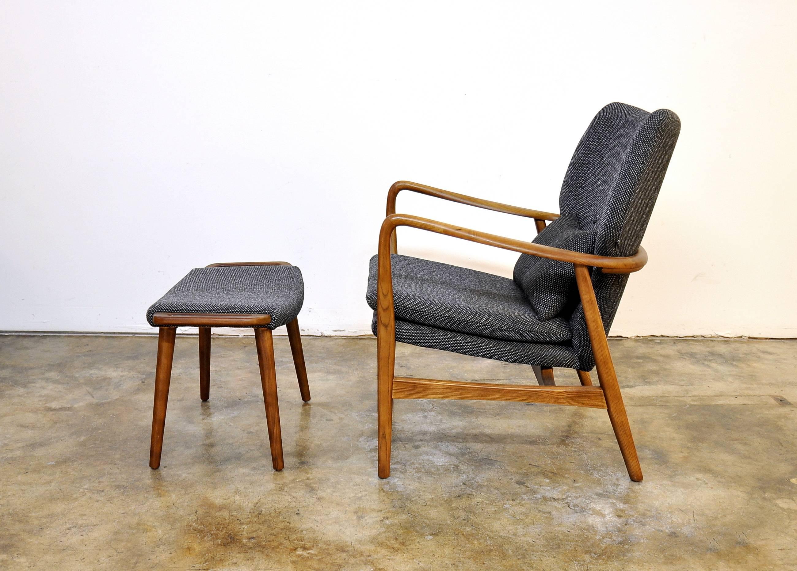 This rare mid-century Danish Modern stained beech easy chair features an outstanding design where the floating wingback and seat are encircled by and suspended within the round wood frame that continues seamlessly into shaped armrests and finishes
