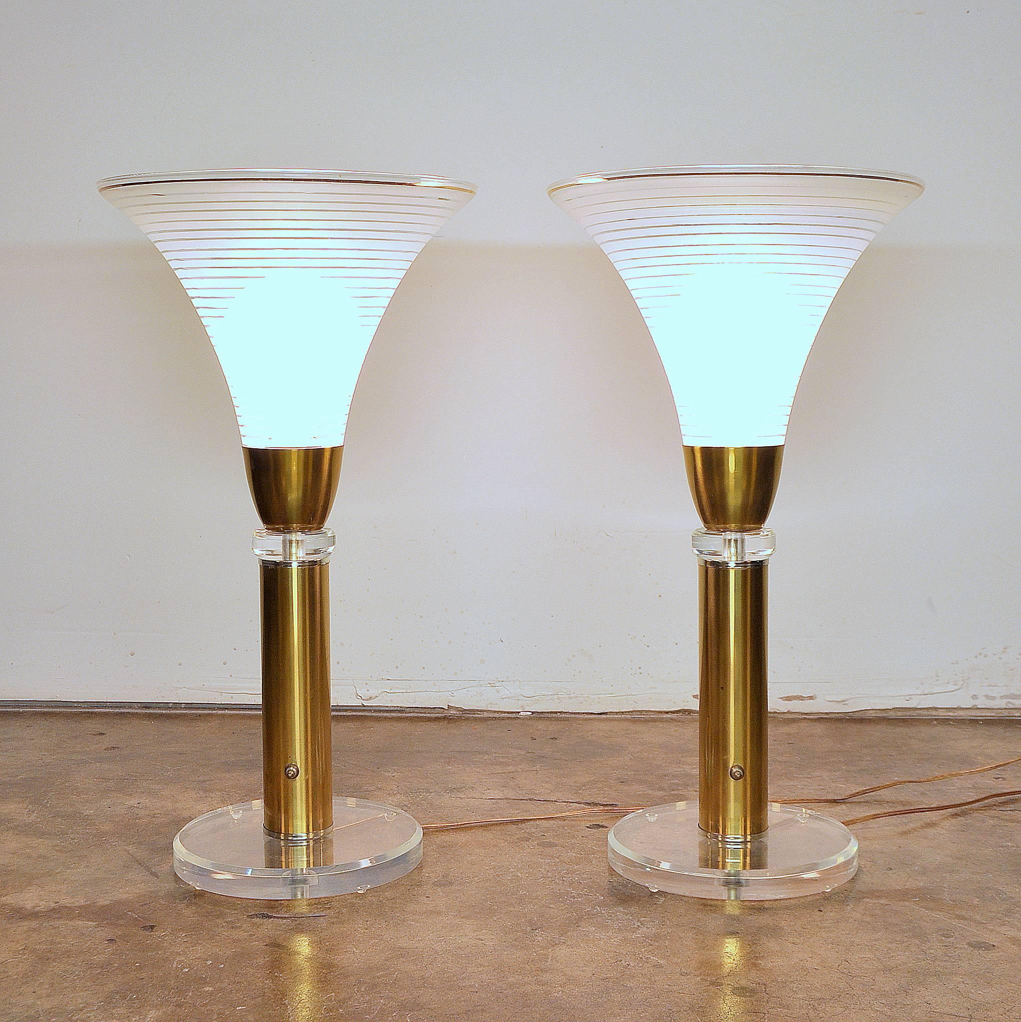Monumental pair of vintage Hollywood Regency brass table lamps with striped clear and frosted Italian blown glass tulip shades and thick circular lucite bases. Estate fresh and in amazing condition, one owner examples of high end mid century modern