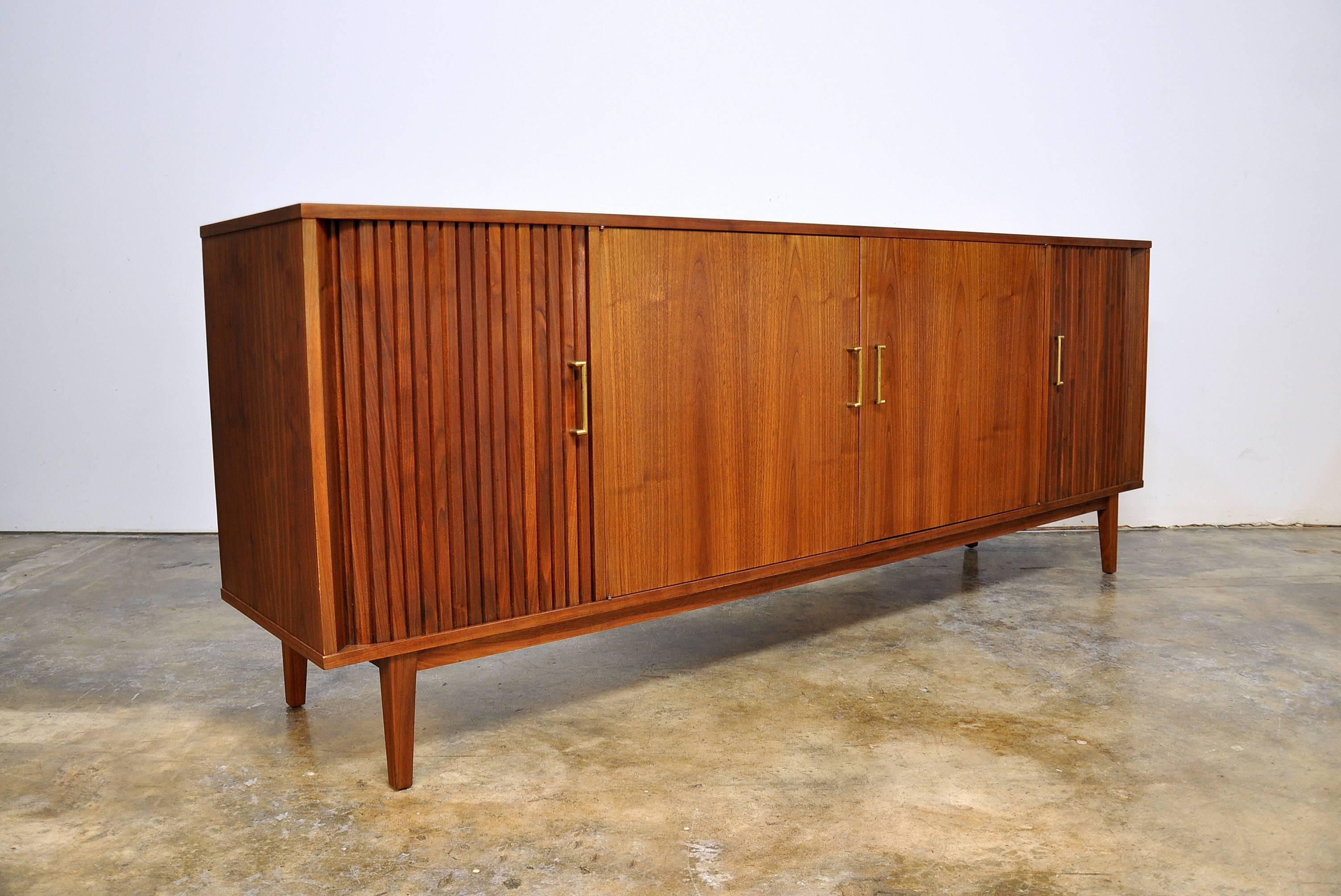 A superb Mid-Century Modern credenza from the Gallery Group that was manufactured in New York in the late 1950s. Having been professionally refinished, the figured walnut's striking grain patterns have come alive and are truly stunning. At nearly 7