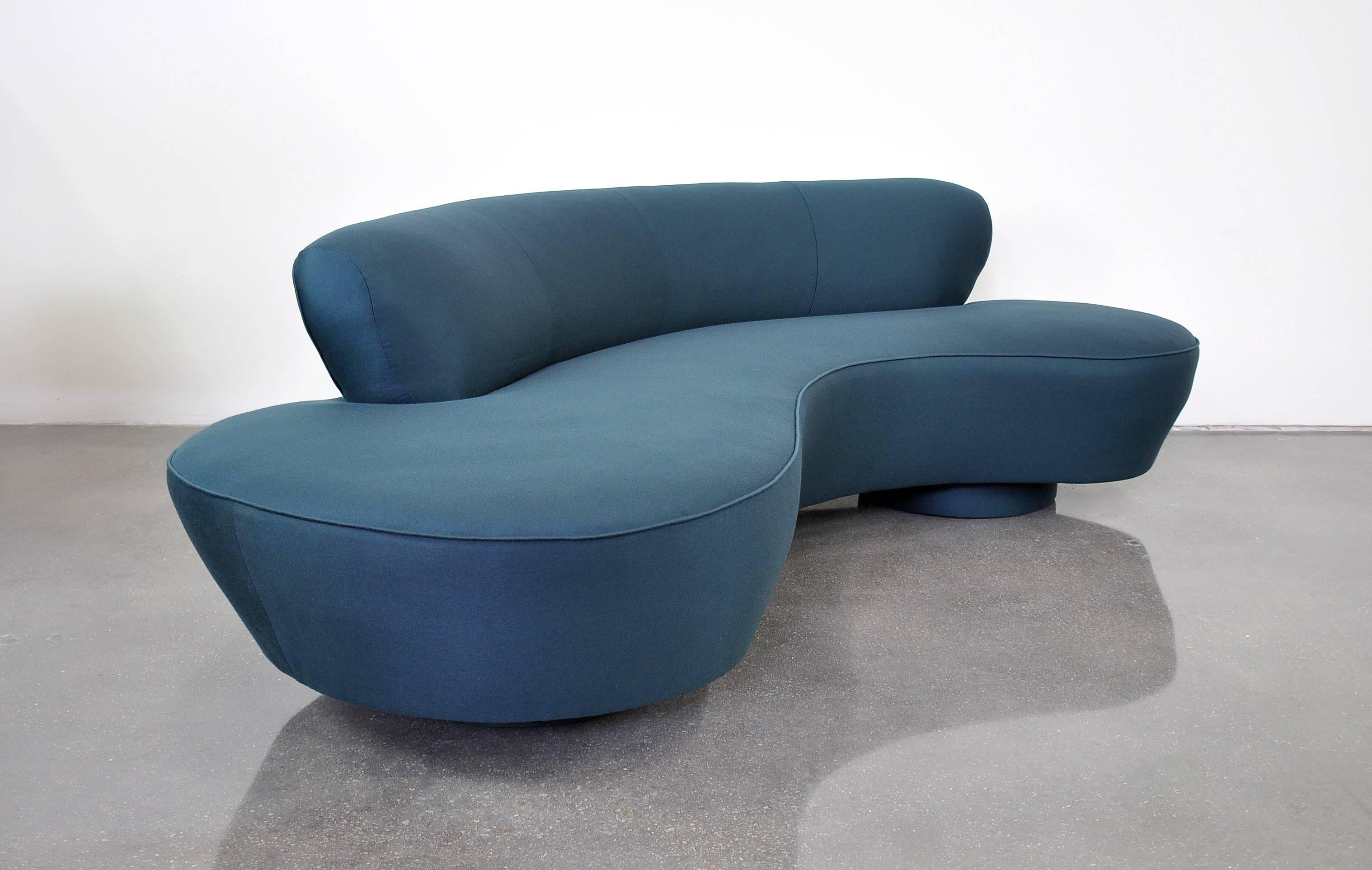 Iconic Mid-Century Modern biomorphic sofa by design legend Vladimir Kagan for Directional reupholstered in an amazing deep blue Maharam fabric. Features a kidney or cloud shape with round upholstered bases and Lucite fin. The dark blue wool fabric