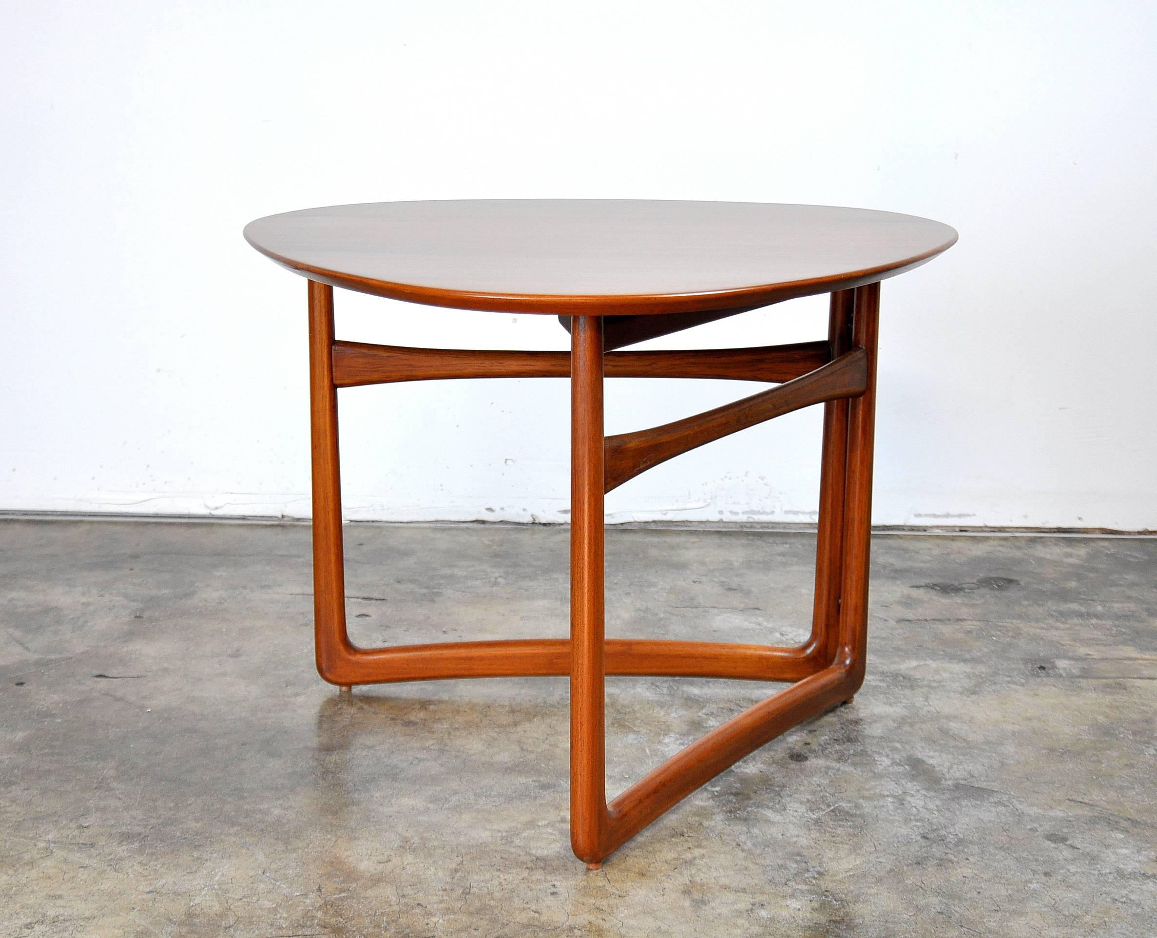 Gorgeous Mid-Century Danish Modern solid teak occasional table, model FD 18/57 designed by Peter Hvidt and Orla Mølgaard-Nielsen and manufactured by France and Daverkosen (pre France and Son) in the 1950s. The triangular top rests on a sculptural