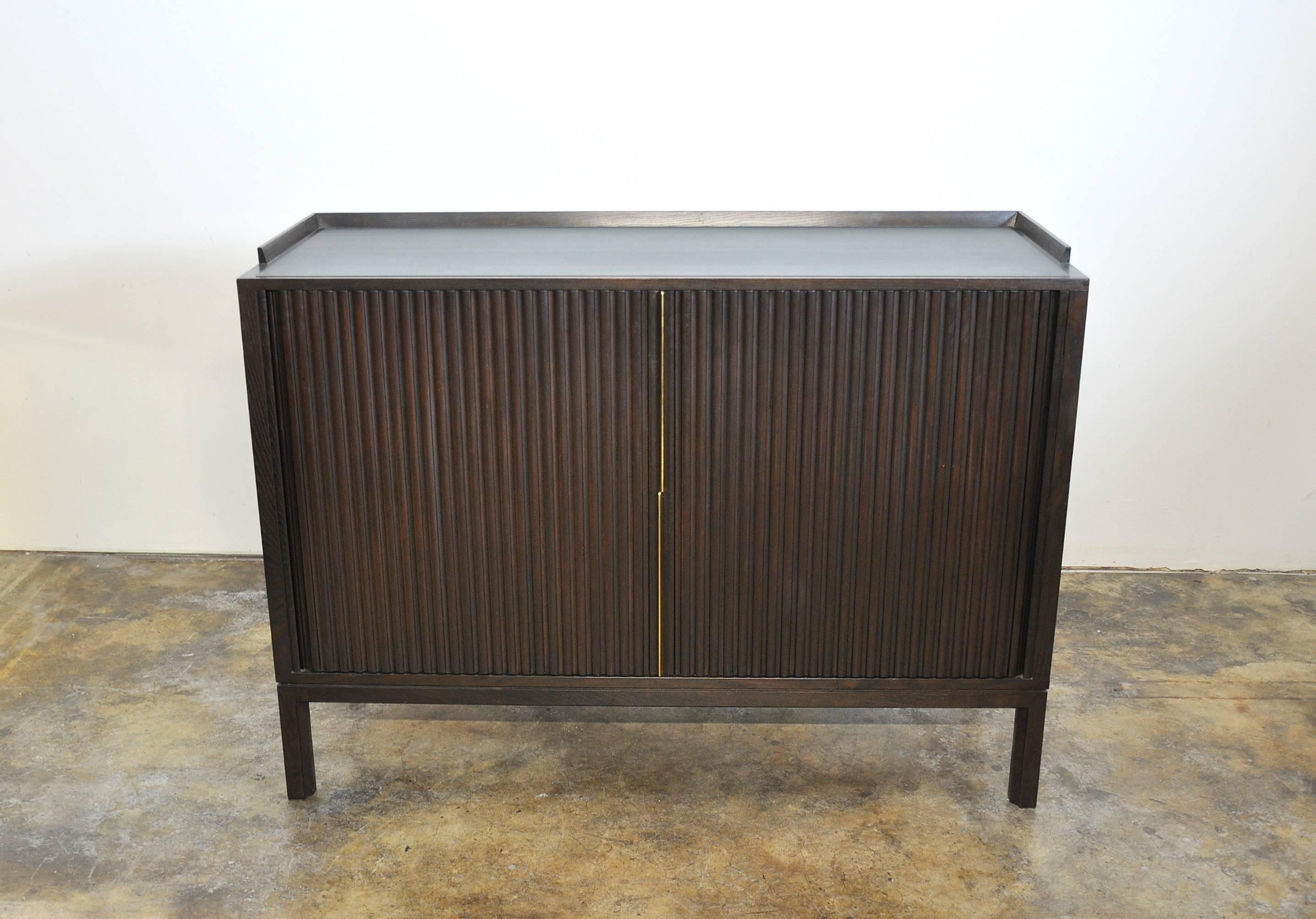 Superb Mid-Century Modern mahogany and brass credenza designed by Ed Wormley for Dunbar in the 1960s, featuring tambour doors, grey stone top and brass hardware. A versatile case piece that can be used as a bar, a credenza, buffet, or a dresser or