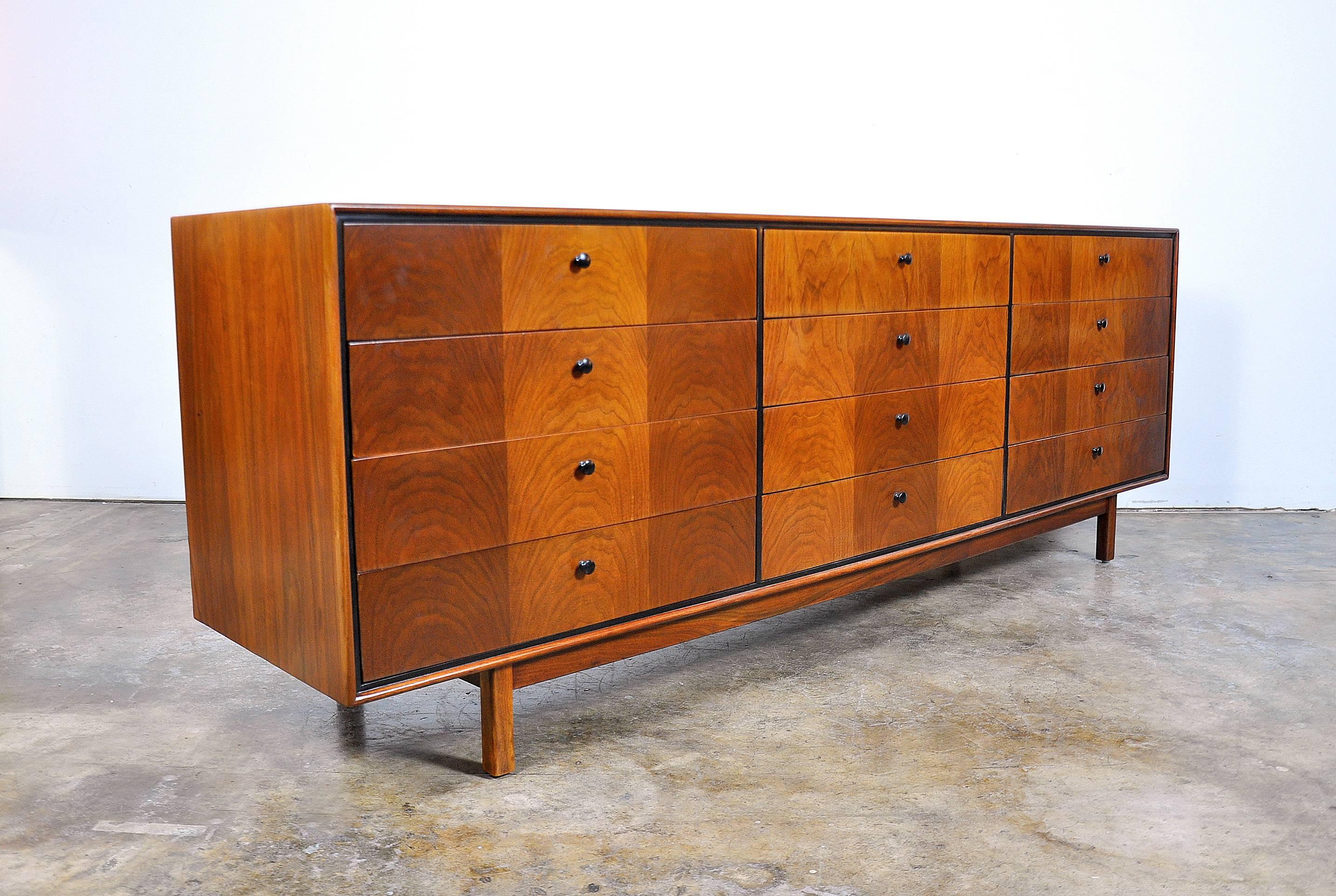 Early and rare Mid-Century Modern vintage 12 drawer low dresser designed by Milo Baughman for Arch Gordon in the 1950s. Professionally refinished, the beautifully grained walnut creates striking patterns. The drawer fronts are fitted with black