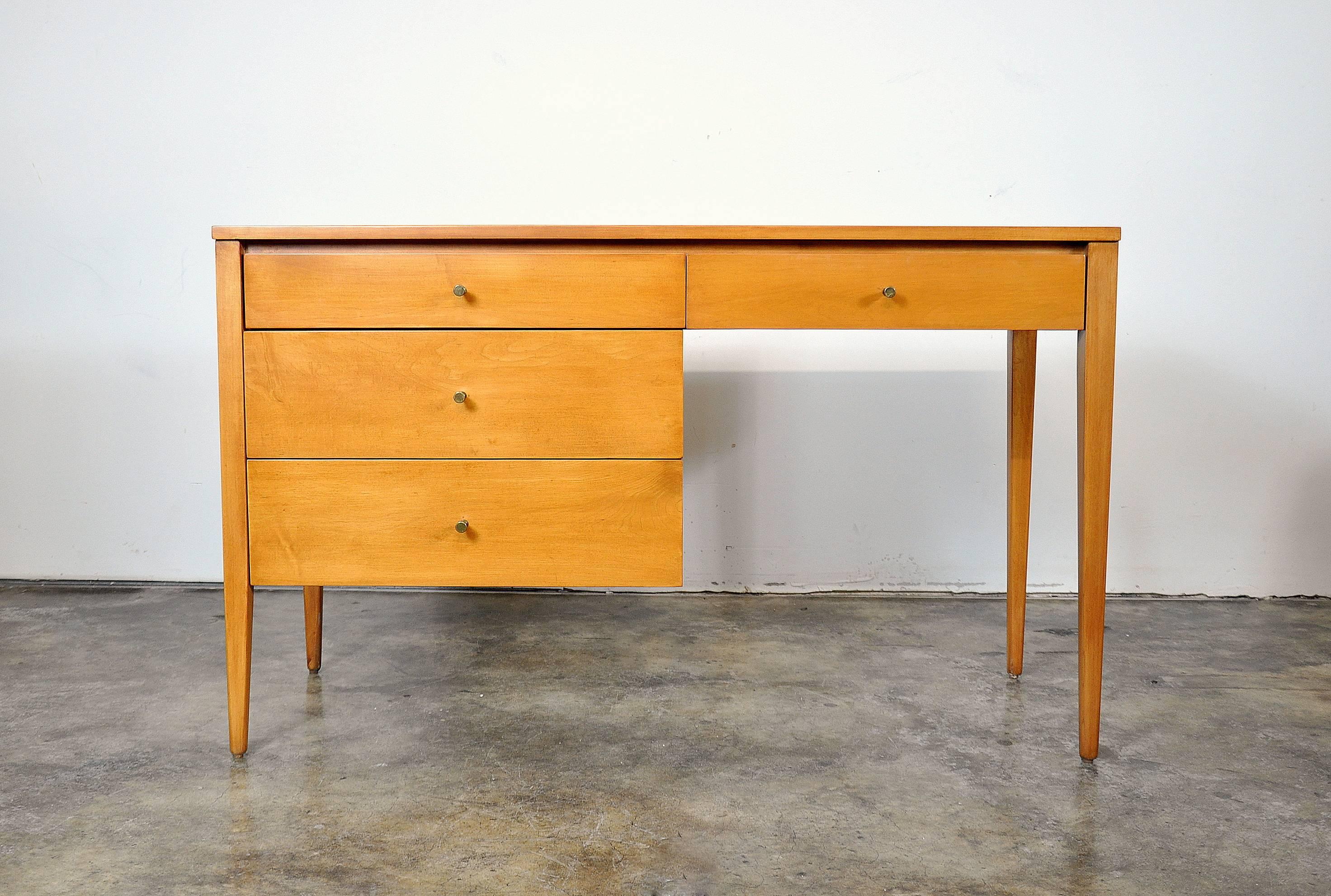 A wonderful Mid-Century Modern vintage writing desk or vanity table designed by Paul McCobb for the immensely popular Planner Group line, manufactured by Winchendon Furniture in the 1950s. Professionally refinished solid maple and featuring four