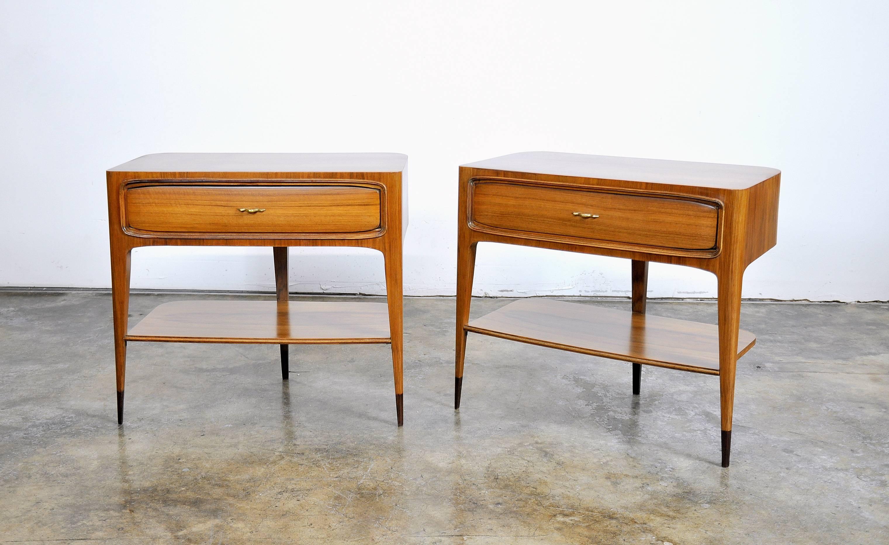 Exquisite and elegant pair of Italian Mid-Century Modern side, end or bedside tables made in Italy in the 1950s and attributed to Paolo Buffa. Professionally refinished, each demilune night stand features a curved back, solid brass zig zag pulls and