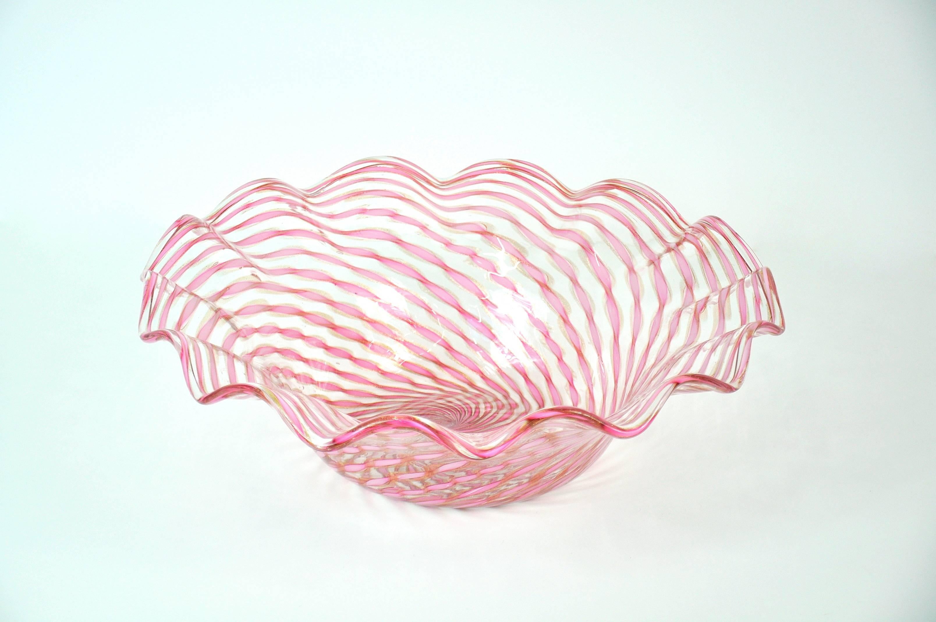 This Art Deco hand blown Venetian art glass centerpiece features pinwheel stripes of soft, pastel pink ribbons and copper aventurine. A gorgeous vintage centerpiece with masterfully scalloped edge.
Salviati and Co. was founded in 1859 in Murano,