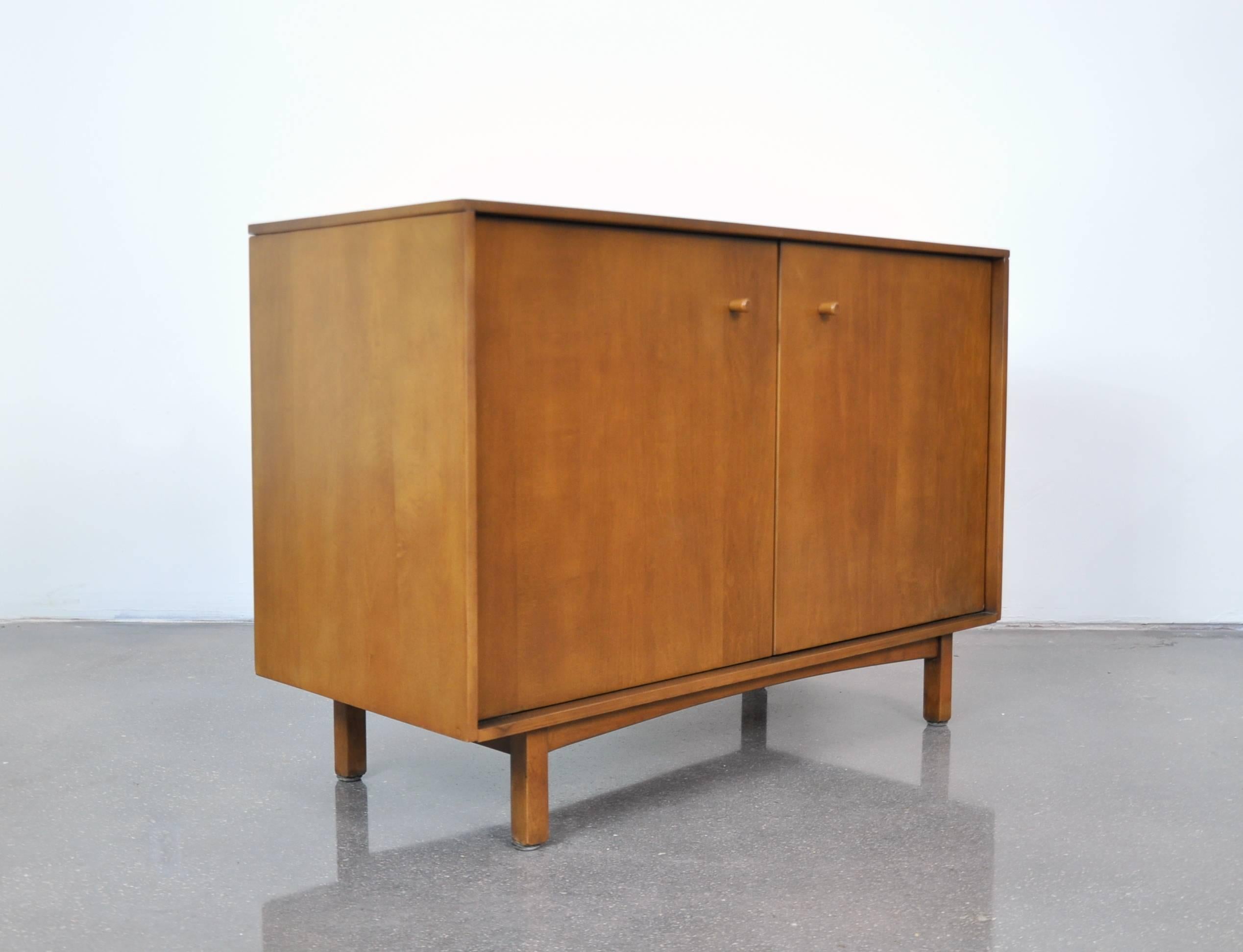 A rare Mid-Century Modern maple bar cabinet designed by Milo Baughman in the early 1950s as part of the Milo Baughman Collection, and manufactured by Murray Furniture Manufacturing Company in WInchendon, Massachusetts. This petite sideboard features