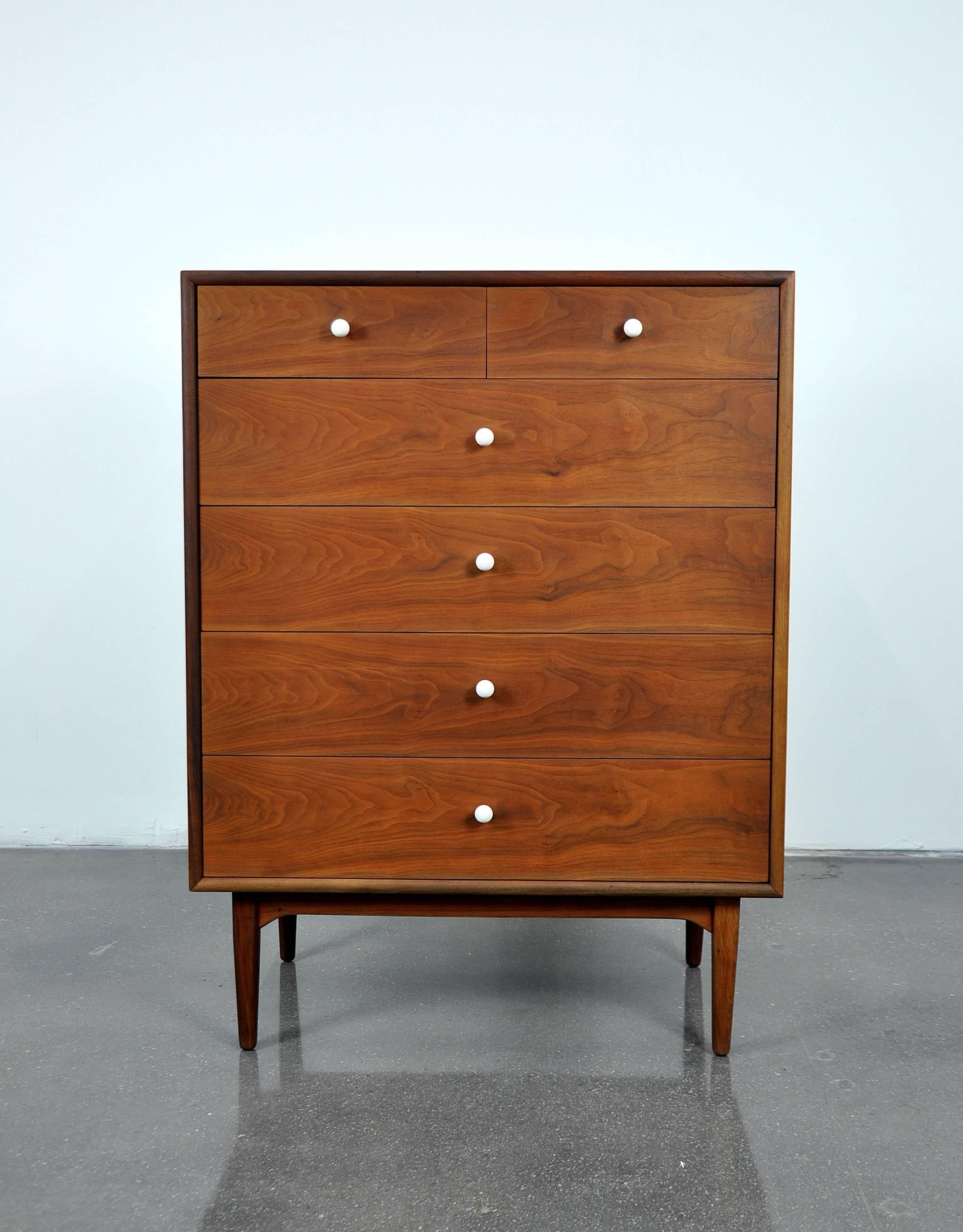 A beautiful Mid-Century Modern walnut highboy dresser from the desirable Declaration line designed by Kipp Stewart and Stewart MacDougall for Drexel in the 1950s. The beautifully grained walnut boasts striking patterns. The tall chest of drawers