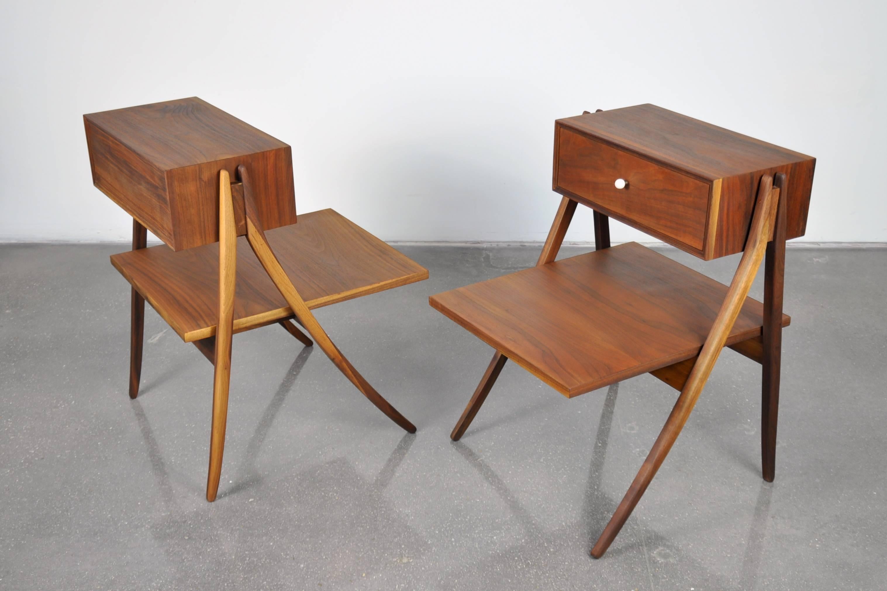 A superb pair of sculptural Mid-Century Modern walnut nightstands designed in the 1950s by Kipp Stewart and Steward MacDougall for the Declaration line by Drexel. The striking two-tier bedside tables feature a floating single drawer and a