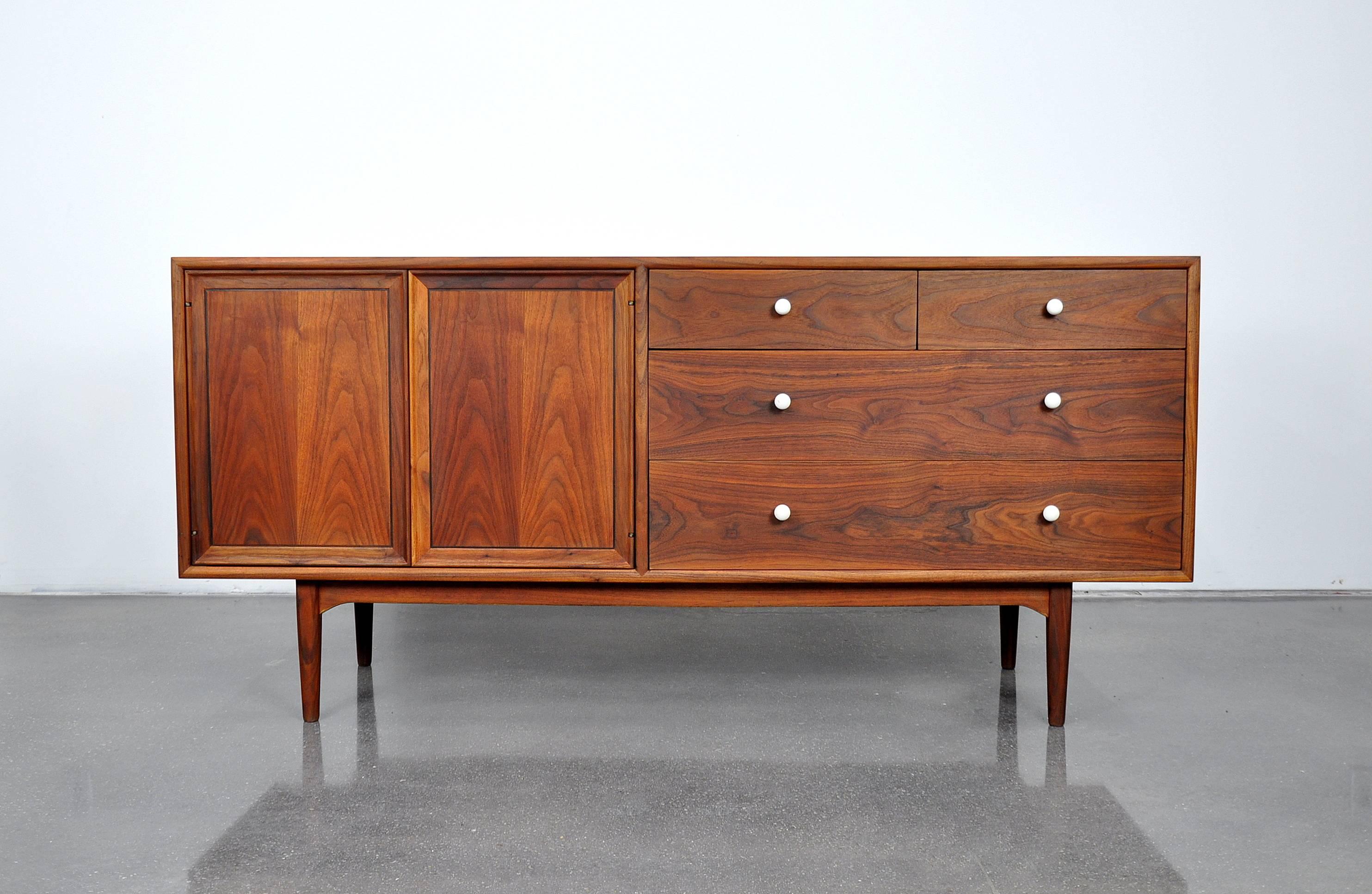 A wonderful Mid-Century Modern bedroom set including a vintage triple dresser, and a pair of nightstands designed in the 1950s by Kipp Stewart and Steward MacDougall for the Drexel Declaration line. The beautifully grained walnut features striking