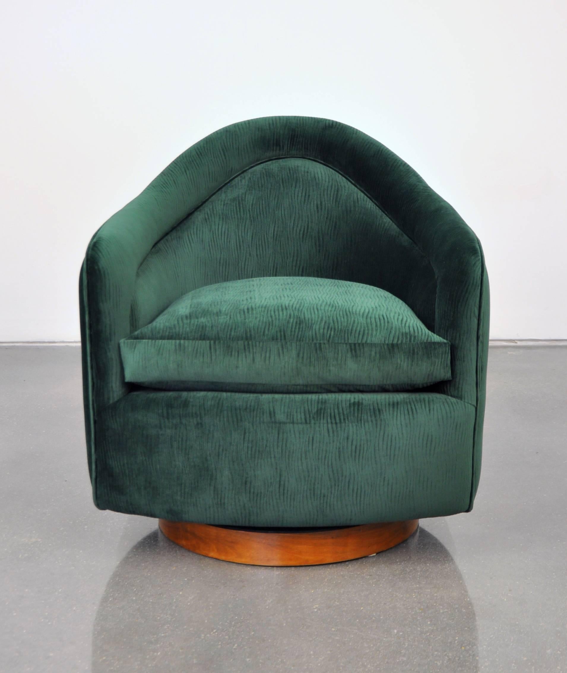 A vintage Mid-Century Modern club chair, fully restored and reupholstered in a mesmerizing deep emerald green velvet, featuring a walnut base with tilting and swiveling mechanism. A very comfortable armchair designed by Milo Baughman for Thayer