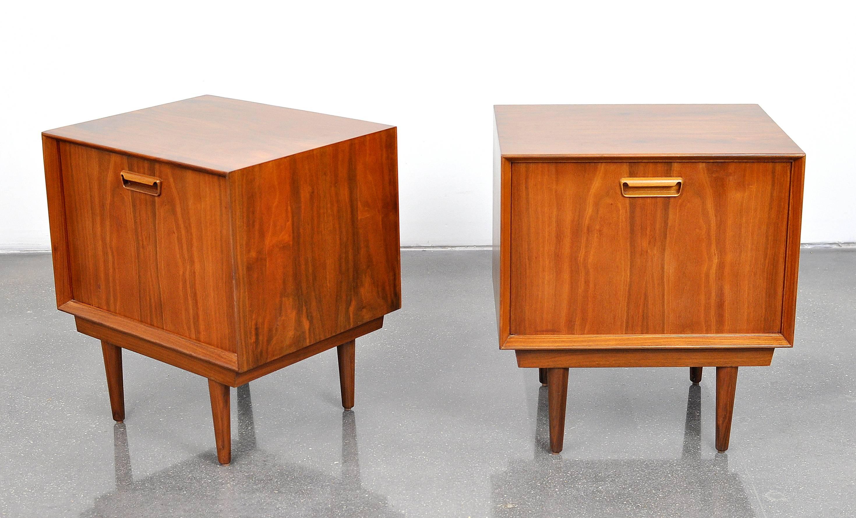 Stunning pair of midcentury Danish modern vintage rosewood side or end tables, designed by Arne Wahl Iversen, and dating from the 1960s. The pair of bedside cabinets feature fall fronts with sculpted pulls, opening to an interior fitted with a