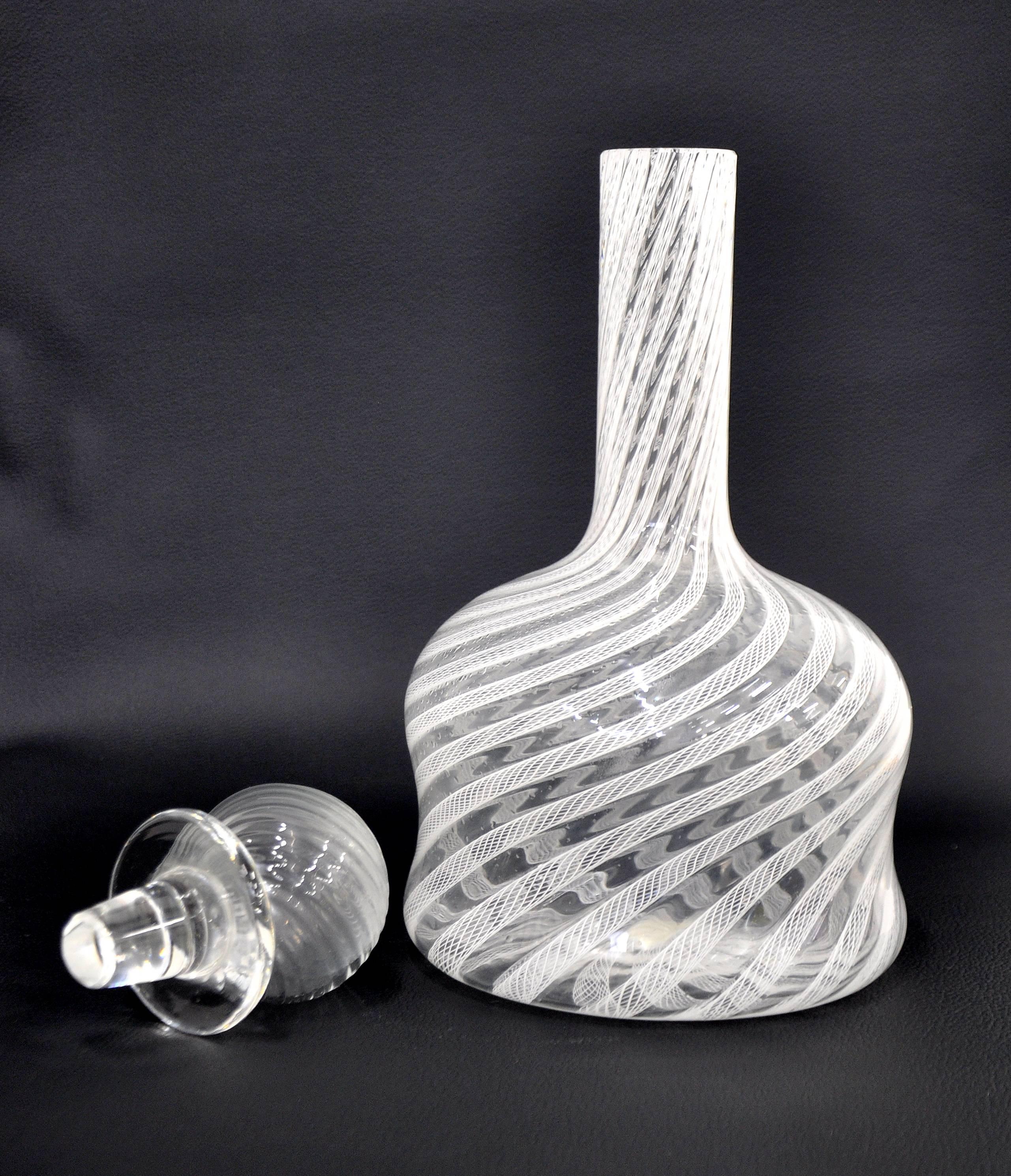 This vintage Italian Mid-Century Modern Venetian art glass bottle features a white filigrana swirl pattern and spherical stopper. Manufactured by Fratelli Toso, the decorative decanter dates from the 1960s. Simple, elegant and timeless, much like