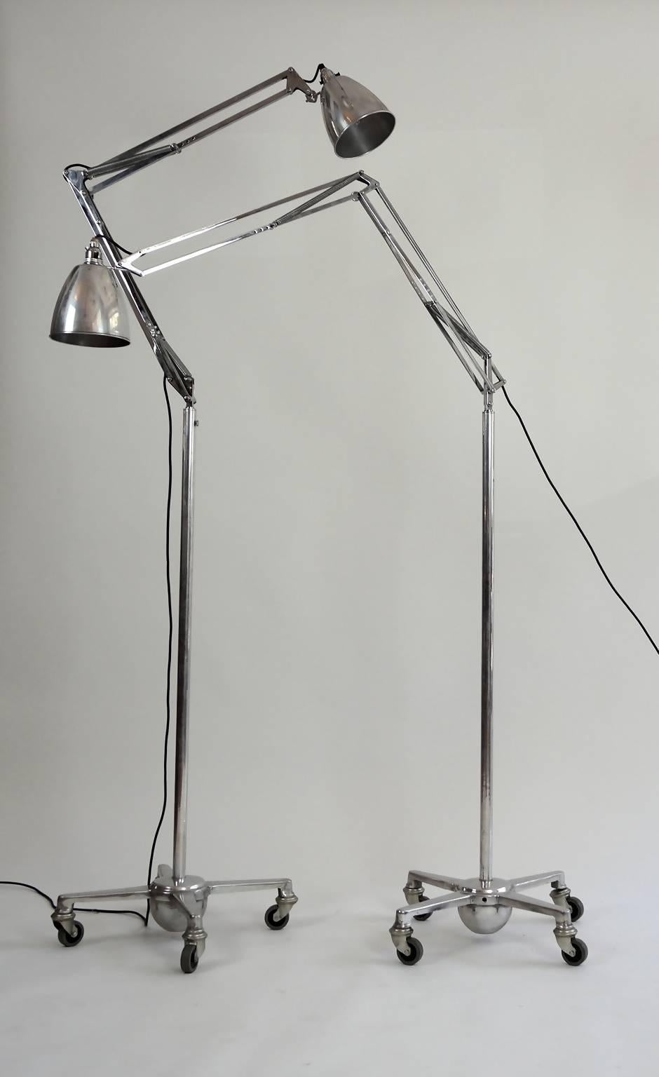 This freestanding floor lamp is made of metal and is mounted on a wheeled floor base. The lamp is designed by George Carwardine for Herbert Terry. A pair is available but they are priced individually.